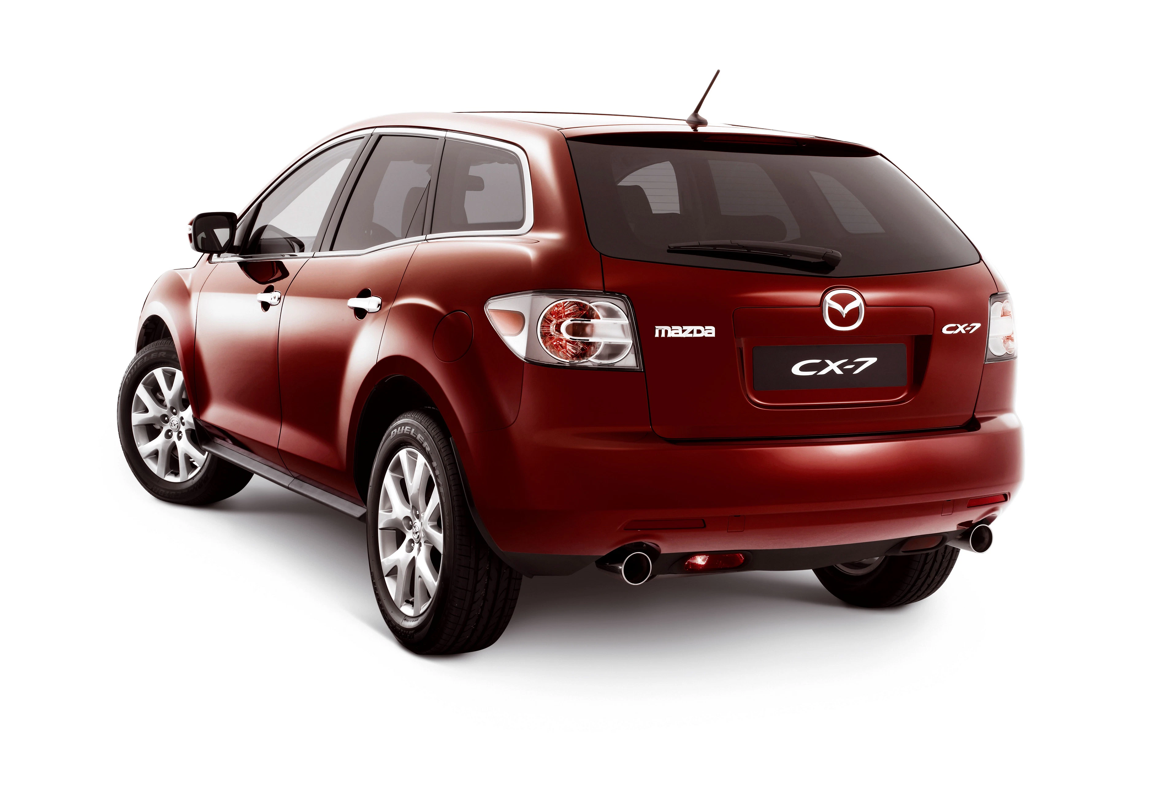 Roter Mazda CX-7 SUV, Heckansicht. Fahrzeug steht auf weißem Hintergrund, hebt stilvolle Rücklichter und Glanzlackierung hervor.
