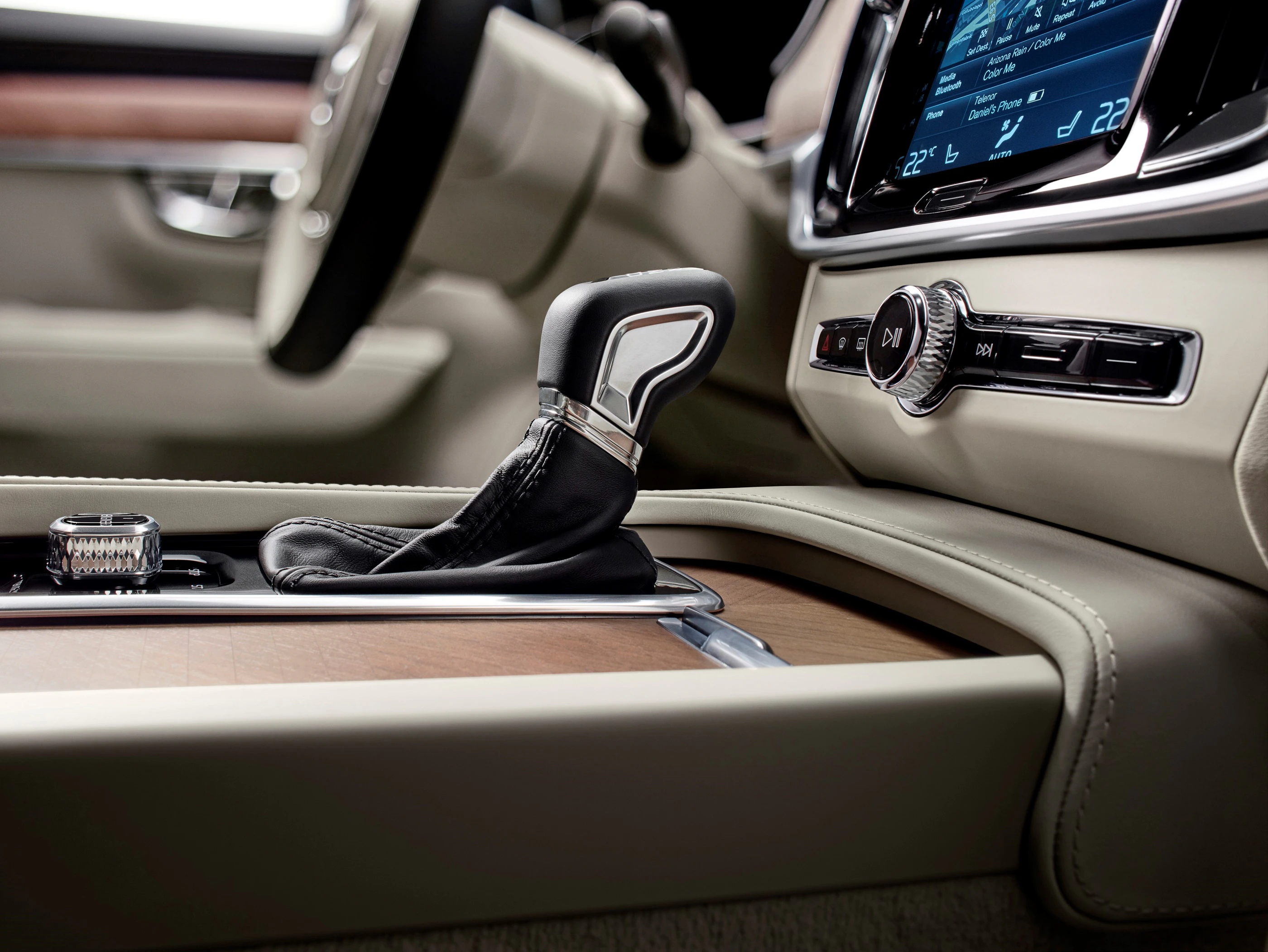 Nahaufnahme eines Automatikgetriebes im modernen Auto. Holzverkleidung und ein Display im Hintergrund. Elegantes Interieurdesign.