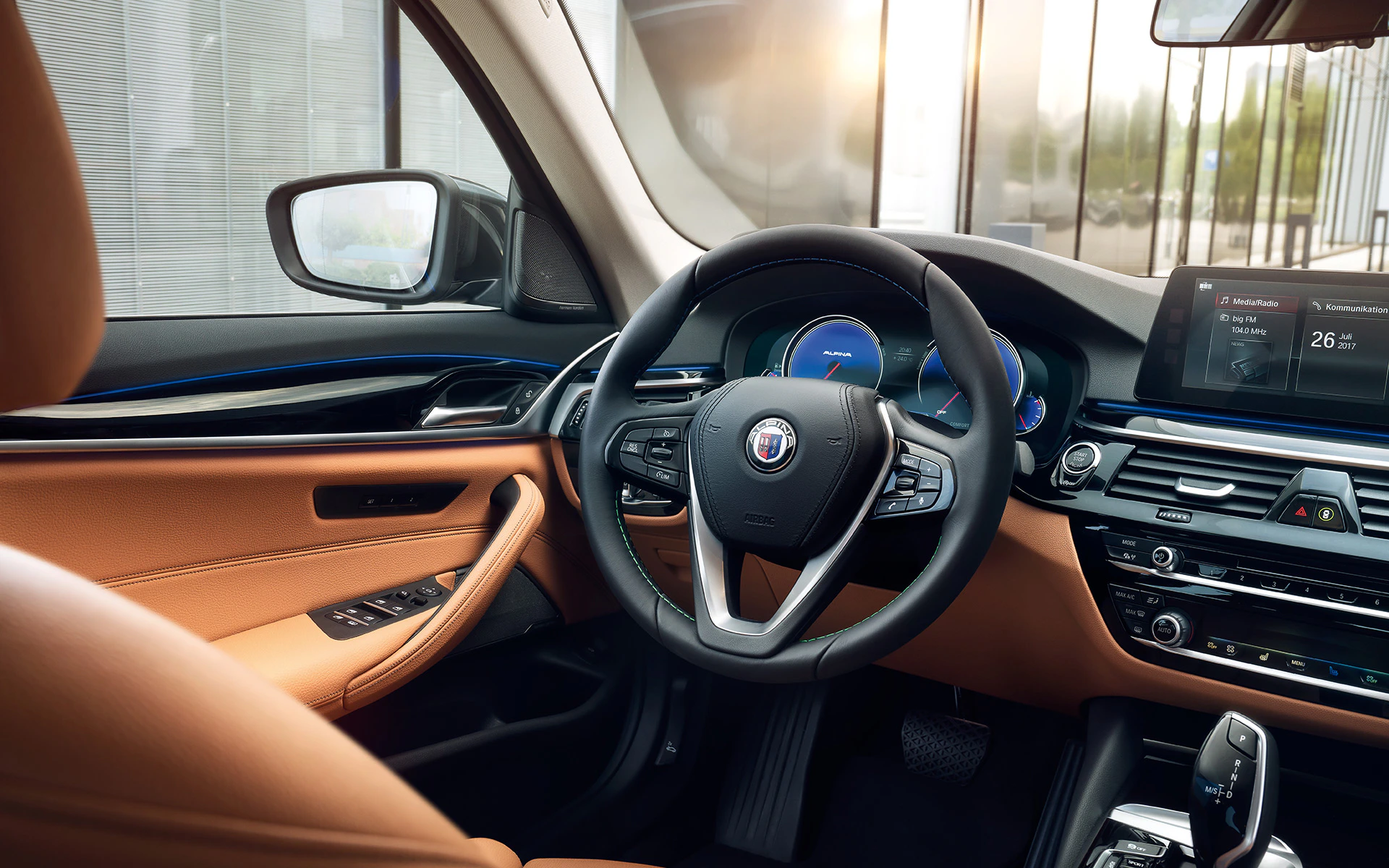 Innenraum eines Luxusautos mit Lederlenkrad, digitalen Anzeigen und Touchscreen, braune Ledersitze und Holzdekor.