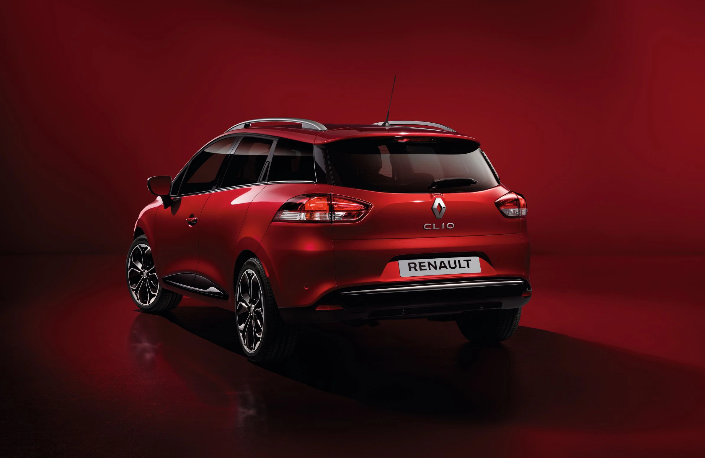 Roter Renault Clio von hinten, stehend auf glänzendem Boden mit rotem Hintergrund.