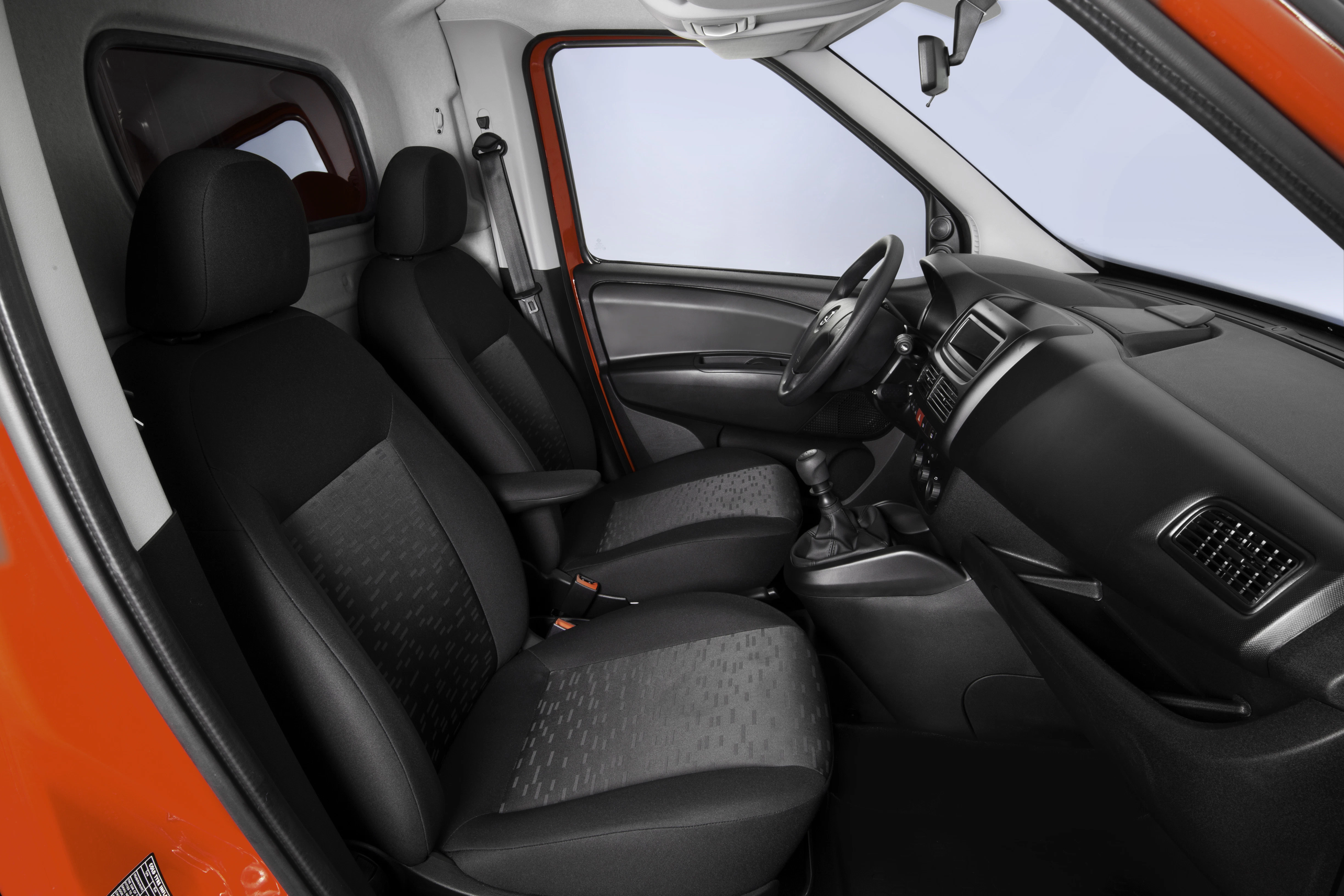 Innenansicht eines Autos mit zwei vorderen Sitzplätzen und orangener Türverkleidung, schwarzer Polsterung und grauem Armaturenbrett.