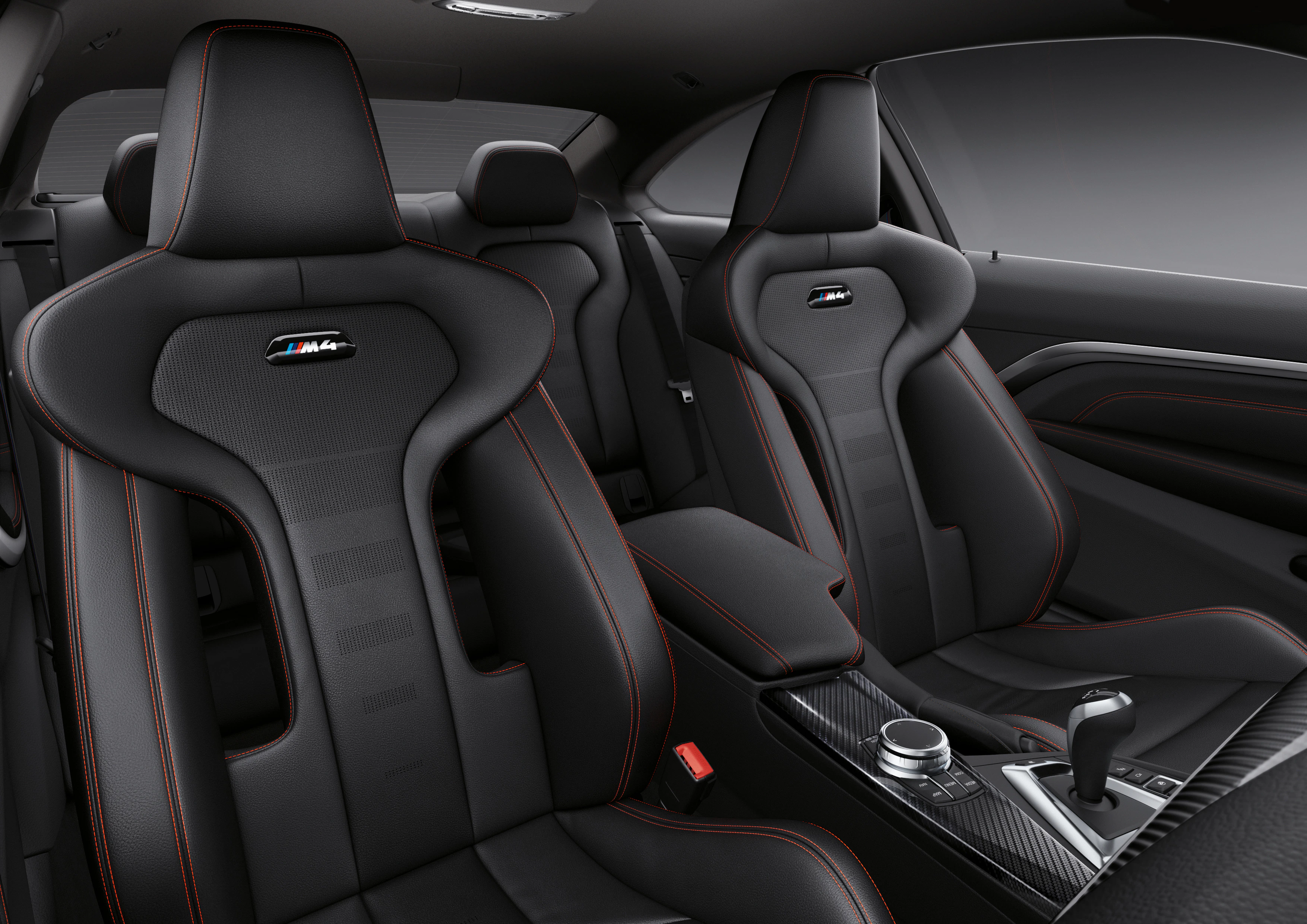 Schwarze Sportsitze in einem Auto mit roten Nähten und einem Carbon-Armaturenbrett, elegante und sportliche Innenausstattung.