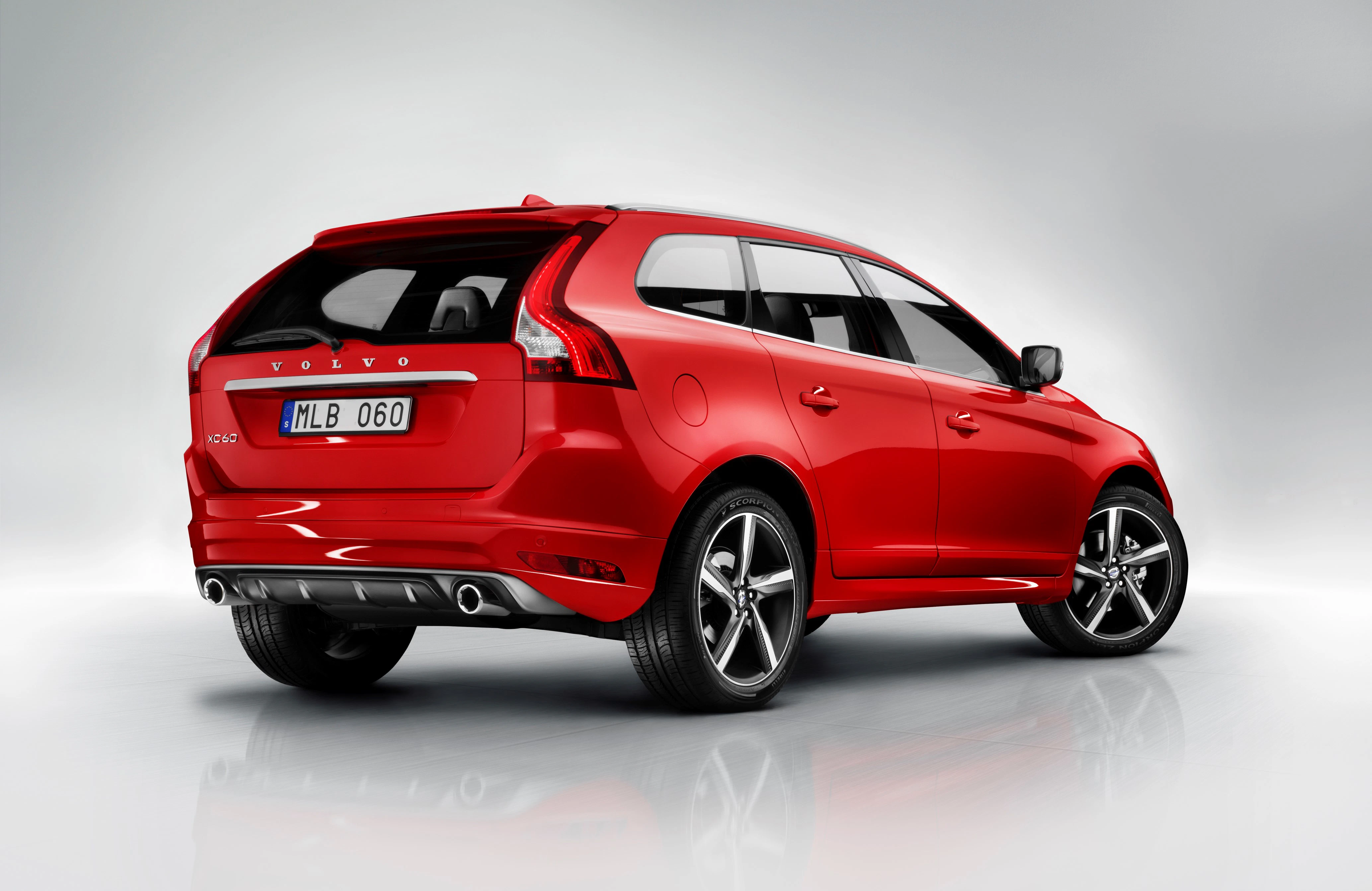Roter Volvo XC60 SUV auf hellem Hintergrund, Heckansicht. Zwei Auspuffrohre und stilvolle Rückleuchten sind erkennbar.