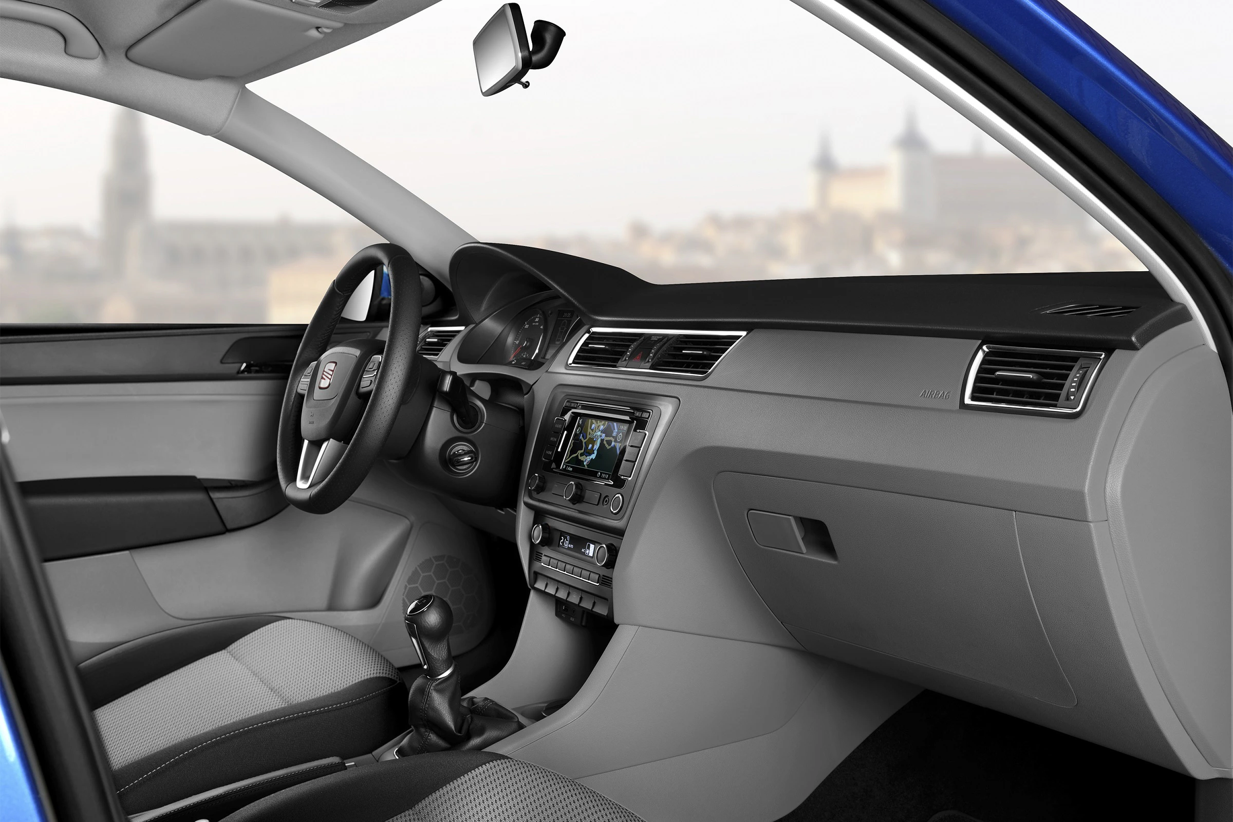 Innenraum eines Autos mit elegantem, modernem Design, grauer und schwarzer Farbgebung. Blick auf das Armaturenbrett und den Schalthebel.