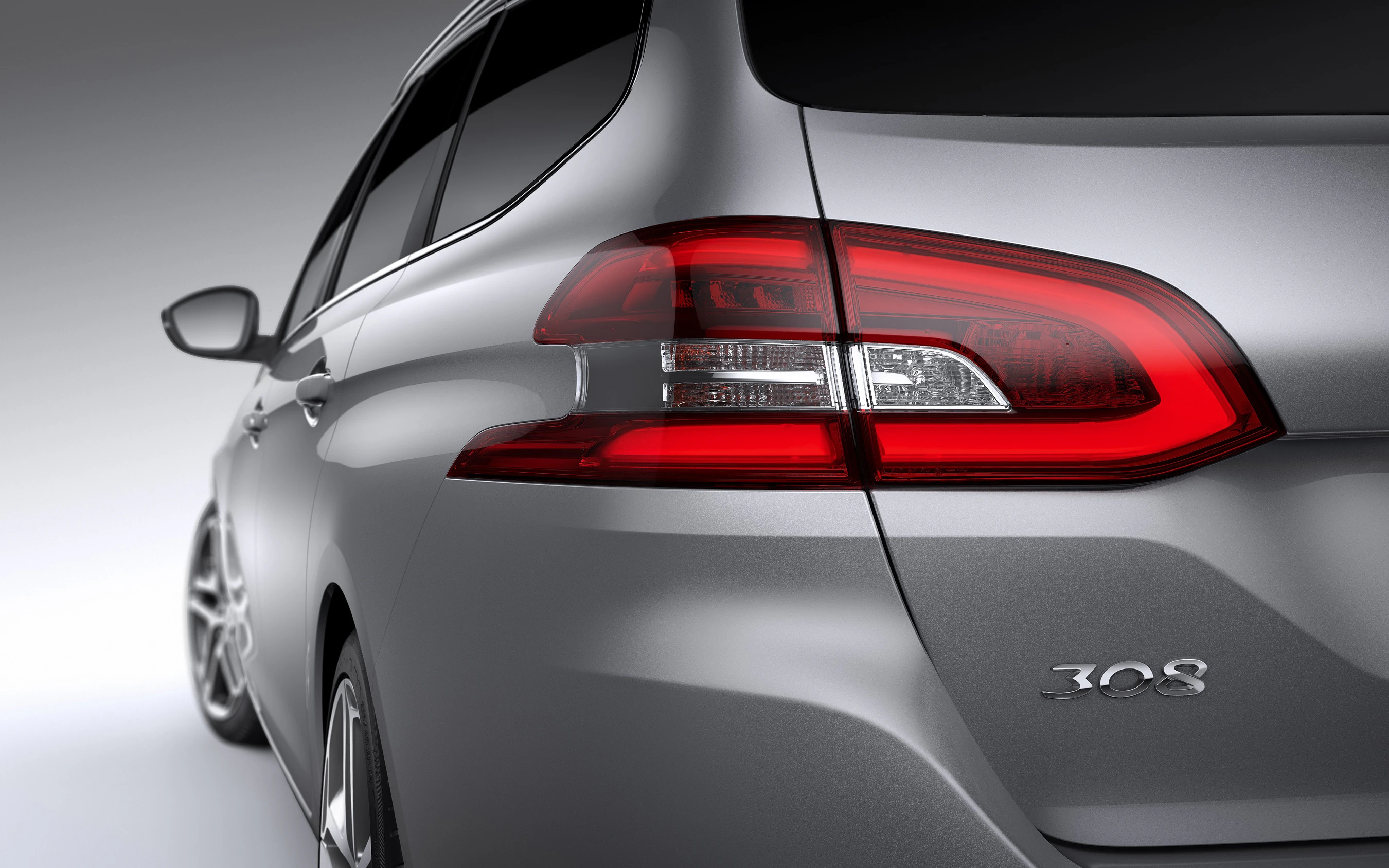 Rückansicht eines silbernen Autos mit auffälligen Rückleuchten und der Aufschrift "308" am Heck.