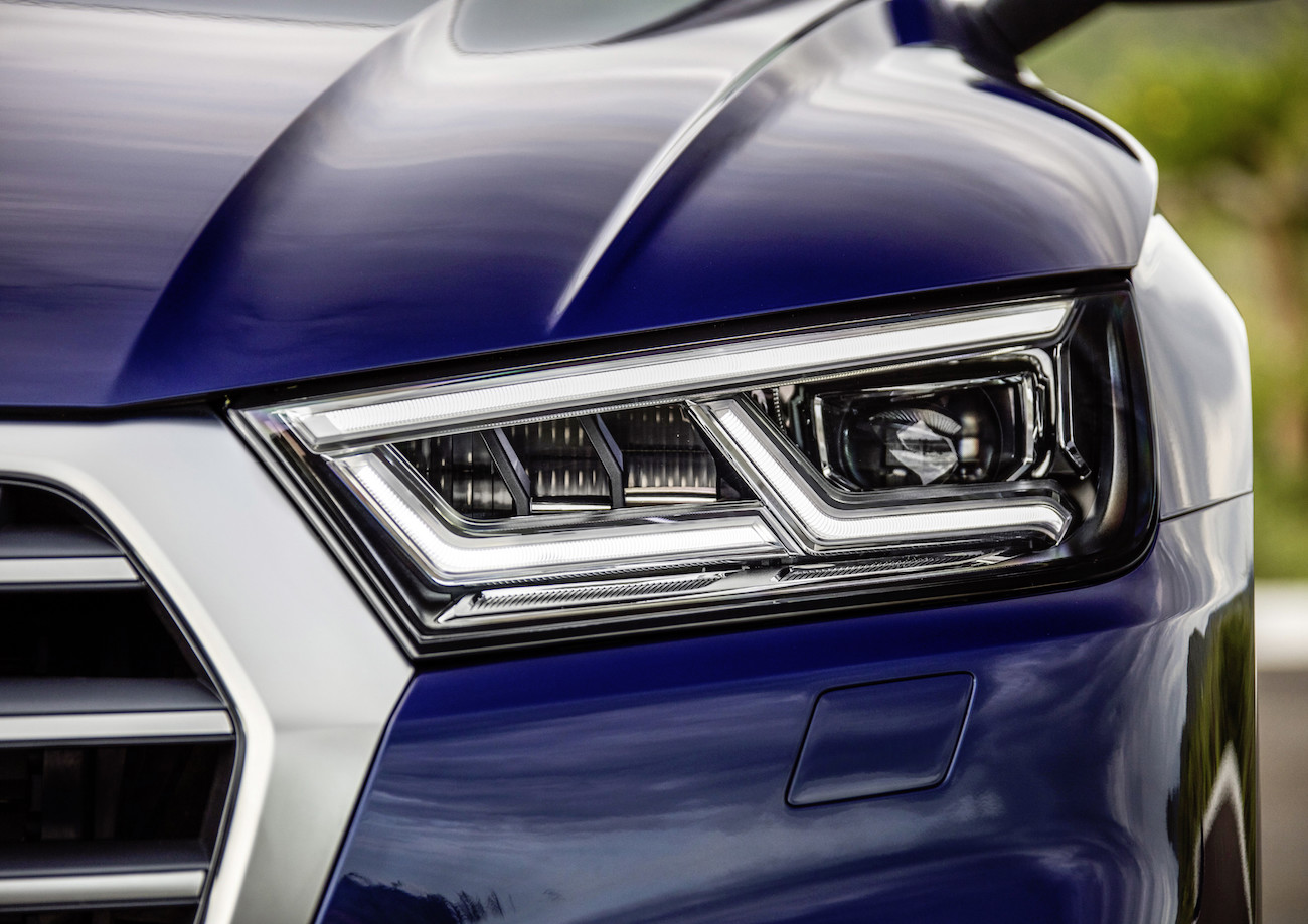 Nahaufnahme eines modernen blauen Autoscheinwerfers mit klaren Linien und sportlichem Design.