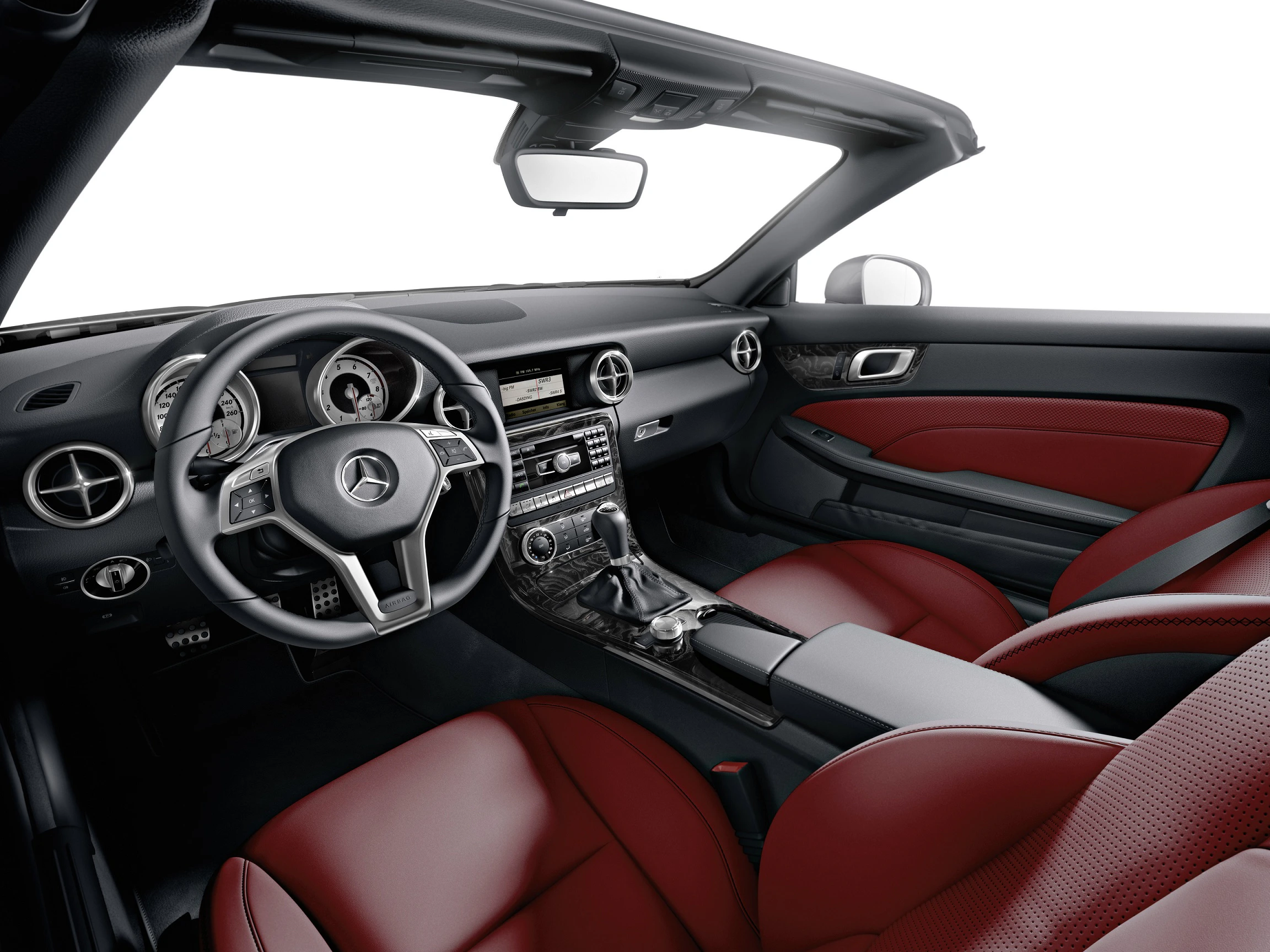 Innenansicht eines Mercedes-Cabriolets mit schwarzem Lenkrad, roter Lederausstattung und moderner Mittelkonsole.