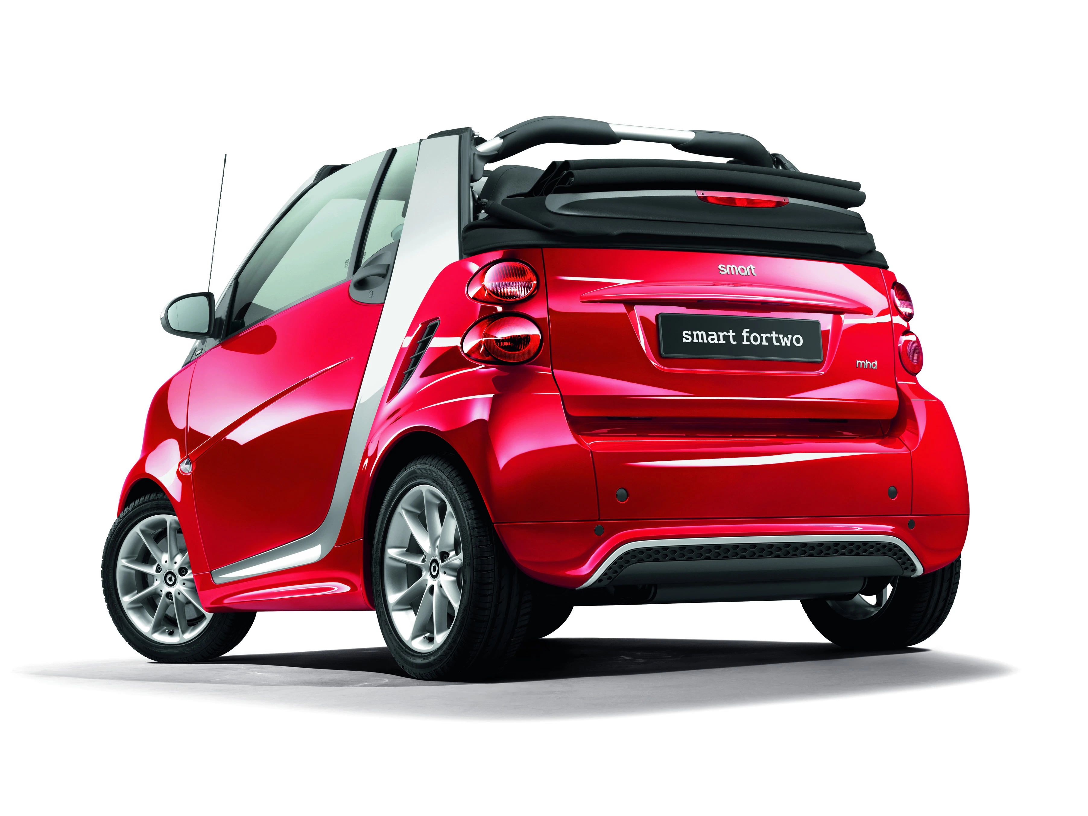 Roter Smart Fortwo Cabrio von hinten, parkend vor weißem Hintergrund. Dach geöffnet, zeigt modernes Design und kompakte Größe.