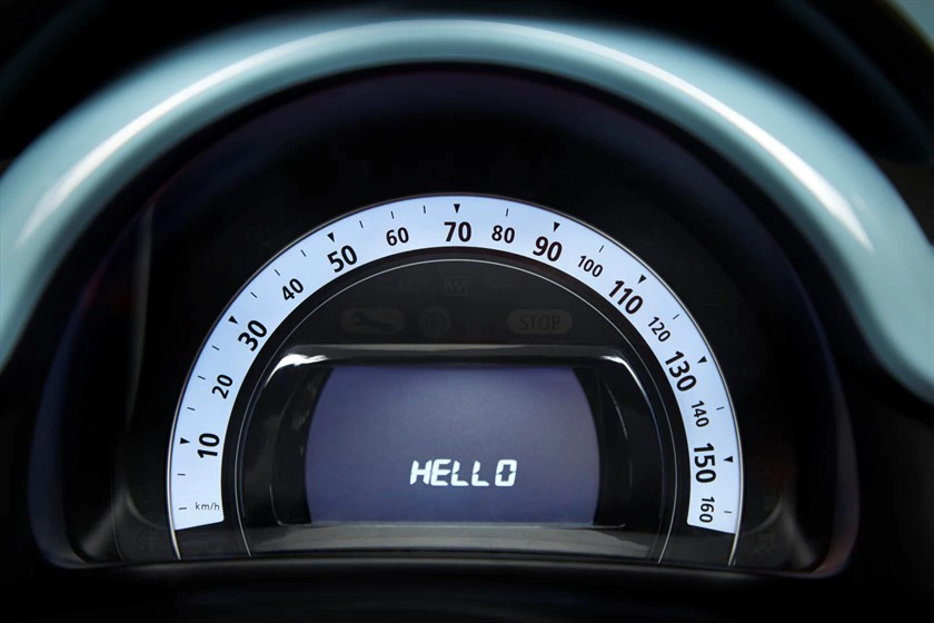 Tachometer eines Autos mit einem digitalen Display, das "HELLO" anzeigt. Skala bis 160 km/h.