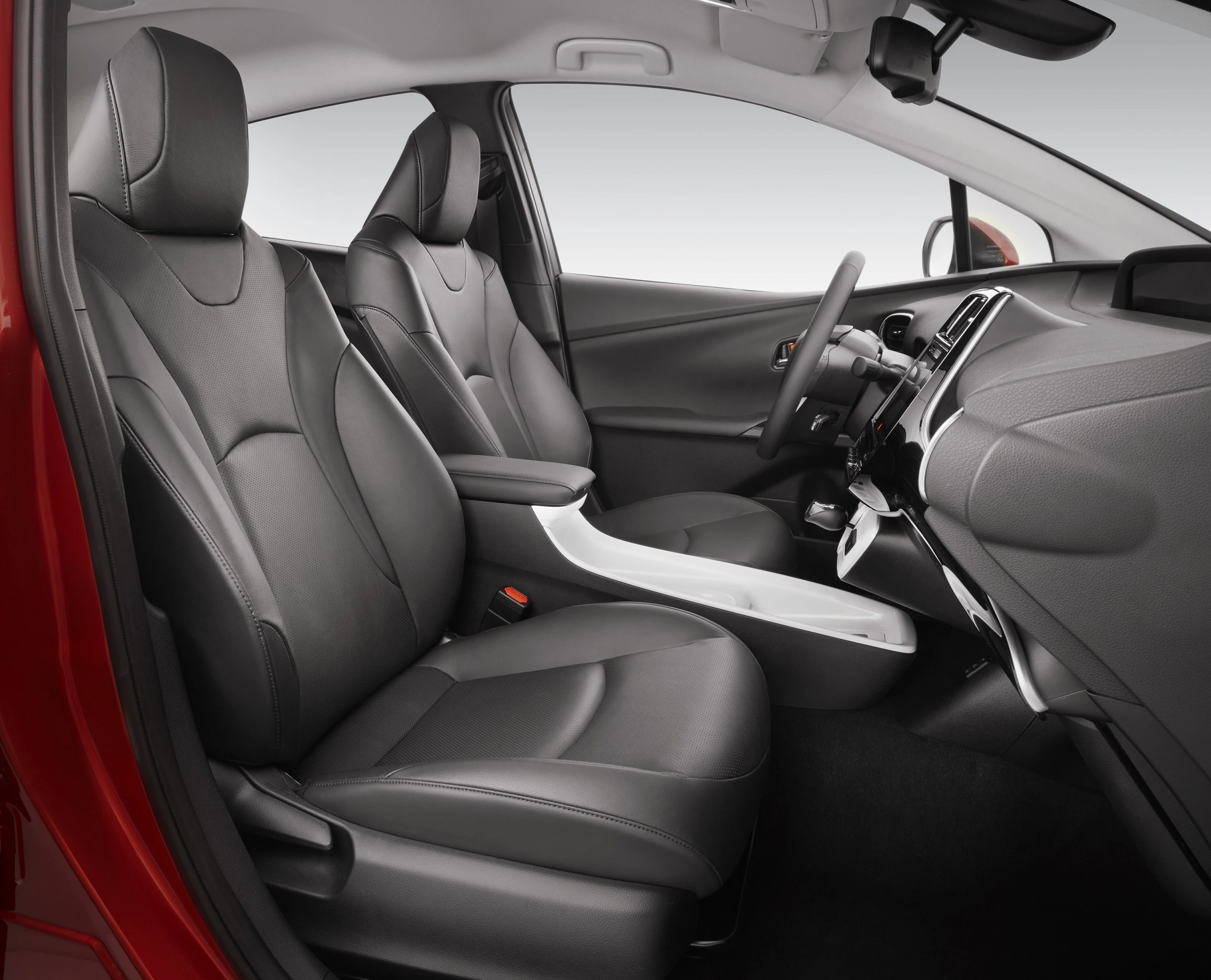 Innenraum eines Autos mit modernen, schwarzen Ledersitzen und einem eleganten Armaturenbrett. Licht fällt sanft von oben.