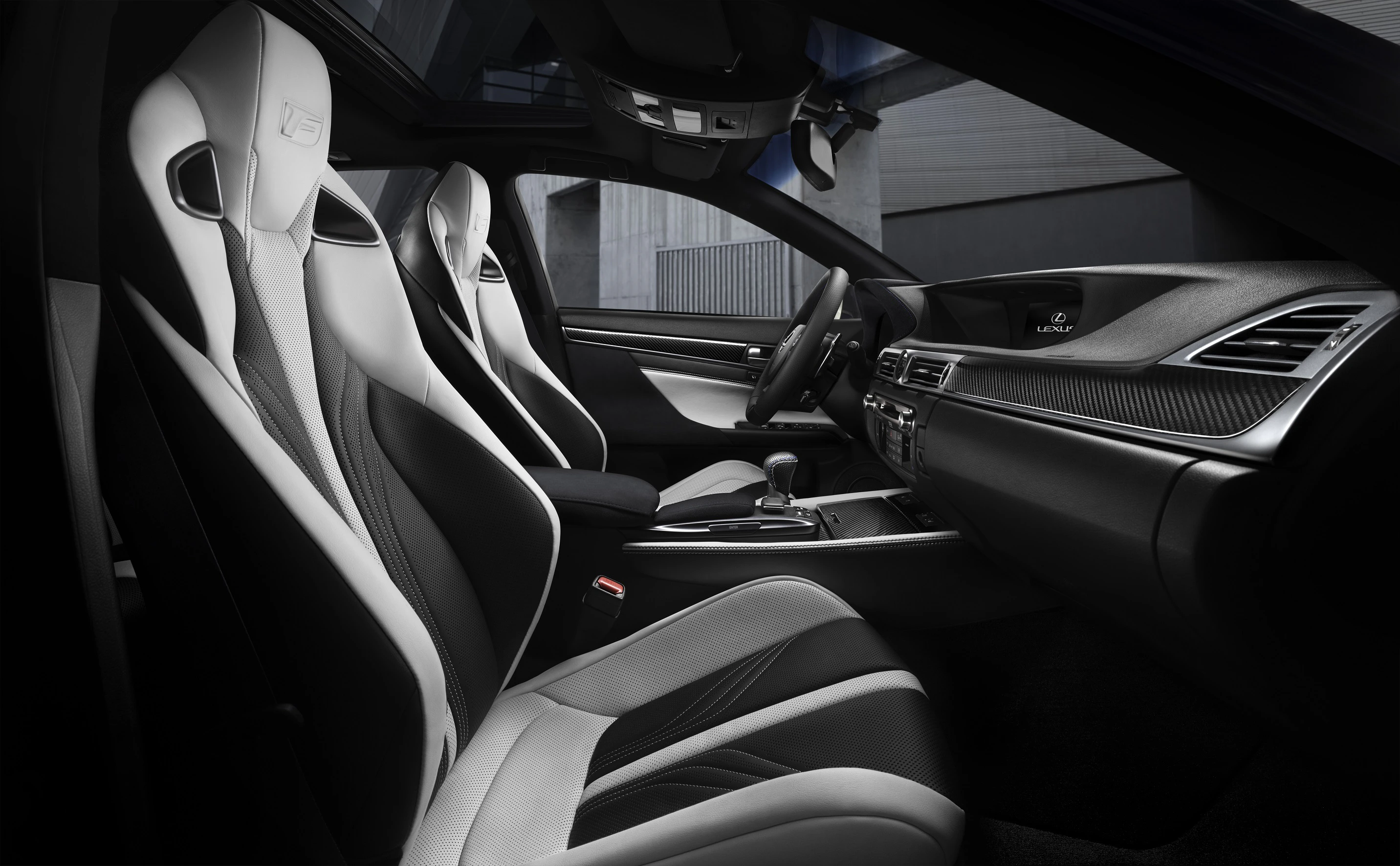 Moderne Autoinnenausstattung mit schwarz-weißen Ledersitzen, Sportlenkrad und Hightech-Armaturenbrett.