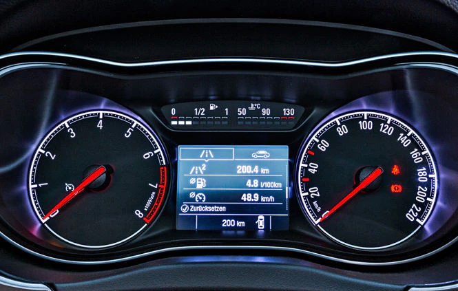 Nahaufnahme eines Auto-Tachometers mit Anzeigen für Geschwindigkeit, Tank, Temperatur und Kilometerstand. Geschwindigkeit zeigt 105 km/h.