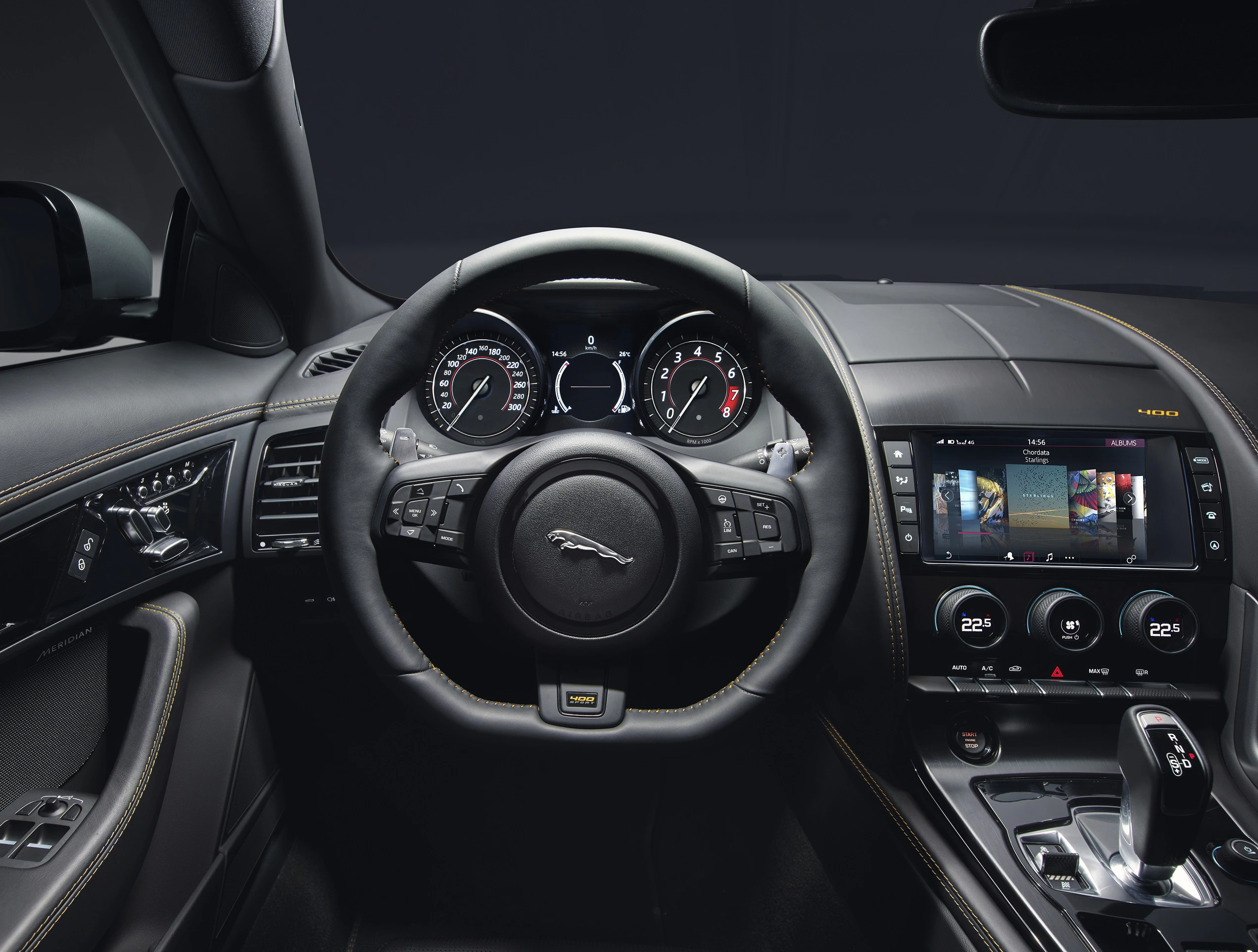 Innenraum eines modernen Autos. Lenkrad, Tachometer und ein Infotainment-Bildschirm sind sichtbar. Hochwertige Materialausstattung.