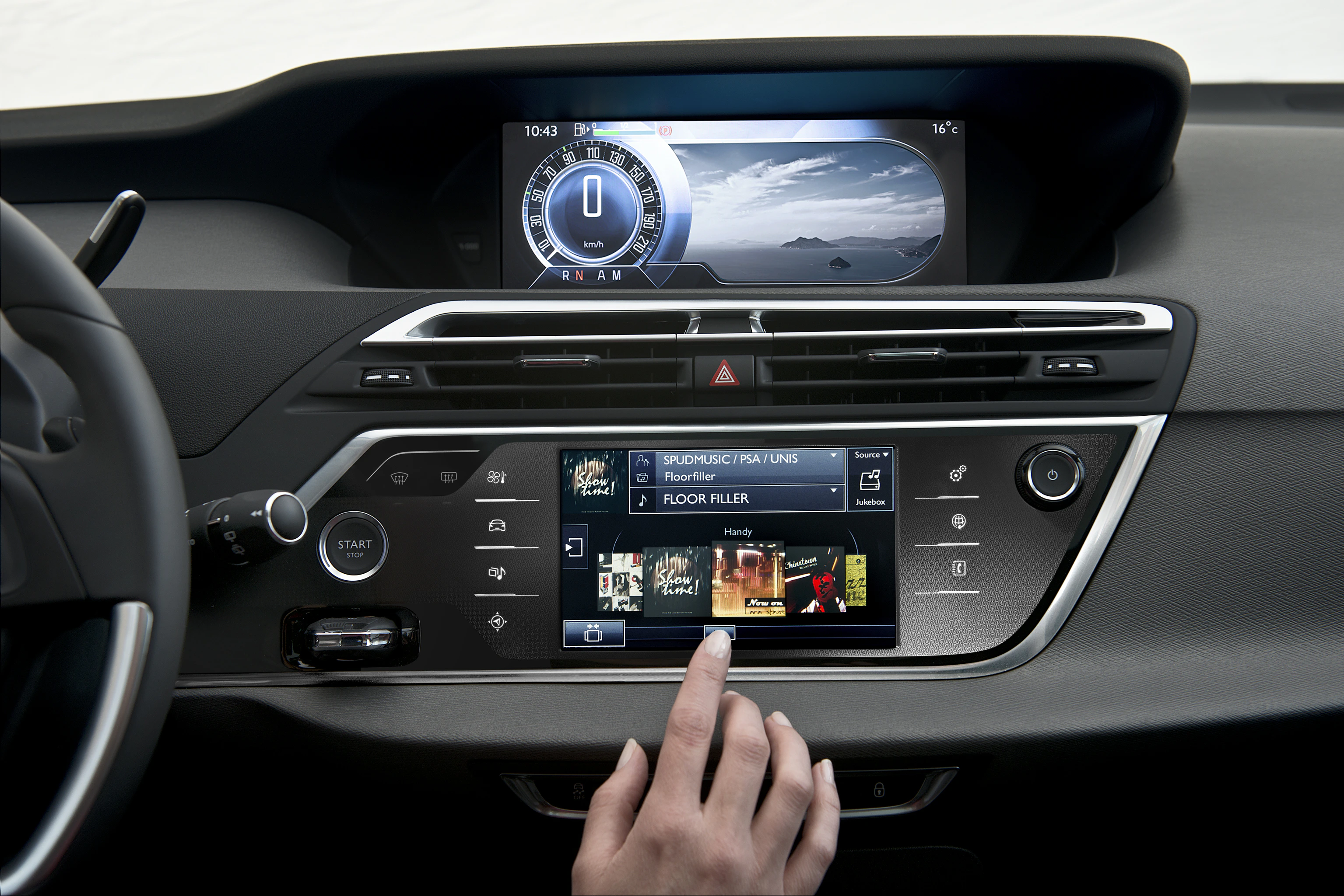 Interieur eines Fahrzeugs mit modernem Touchscreen-Infotainmentsystem, Hand bedient die Musikwiedergabe, digitales Display und Steuerungen sichtbar.