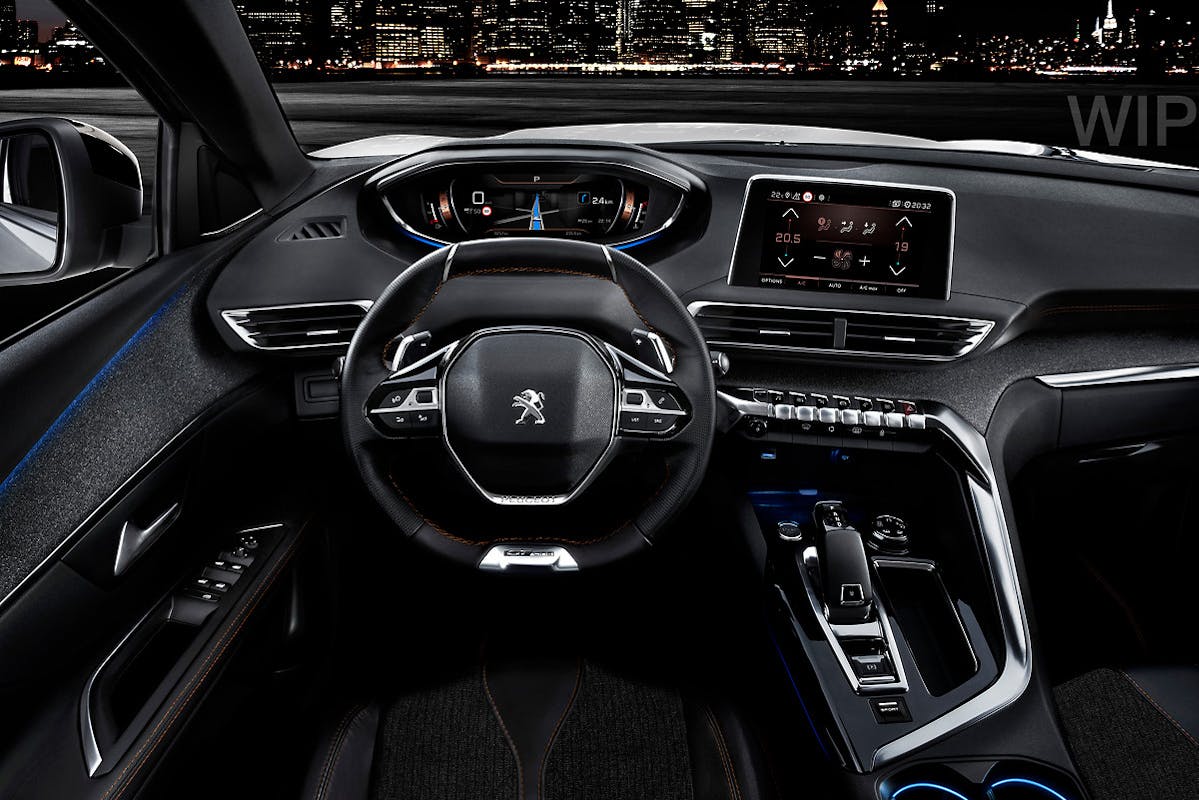 Innenraum eines modernen Autos bei Nacht mit beleuchtetem Armaturenbrett und Display; Stadtlichter im Hintergrund durch die Windschutzscheibe sichtbar.