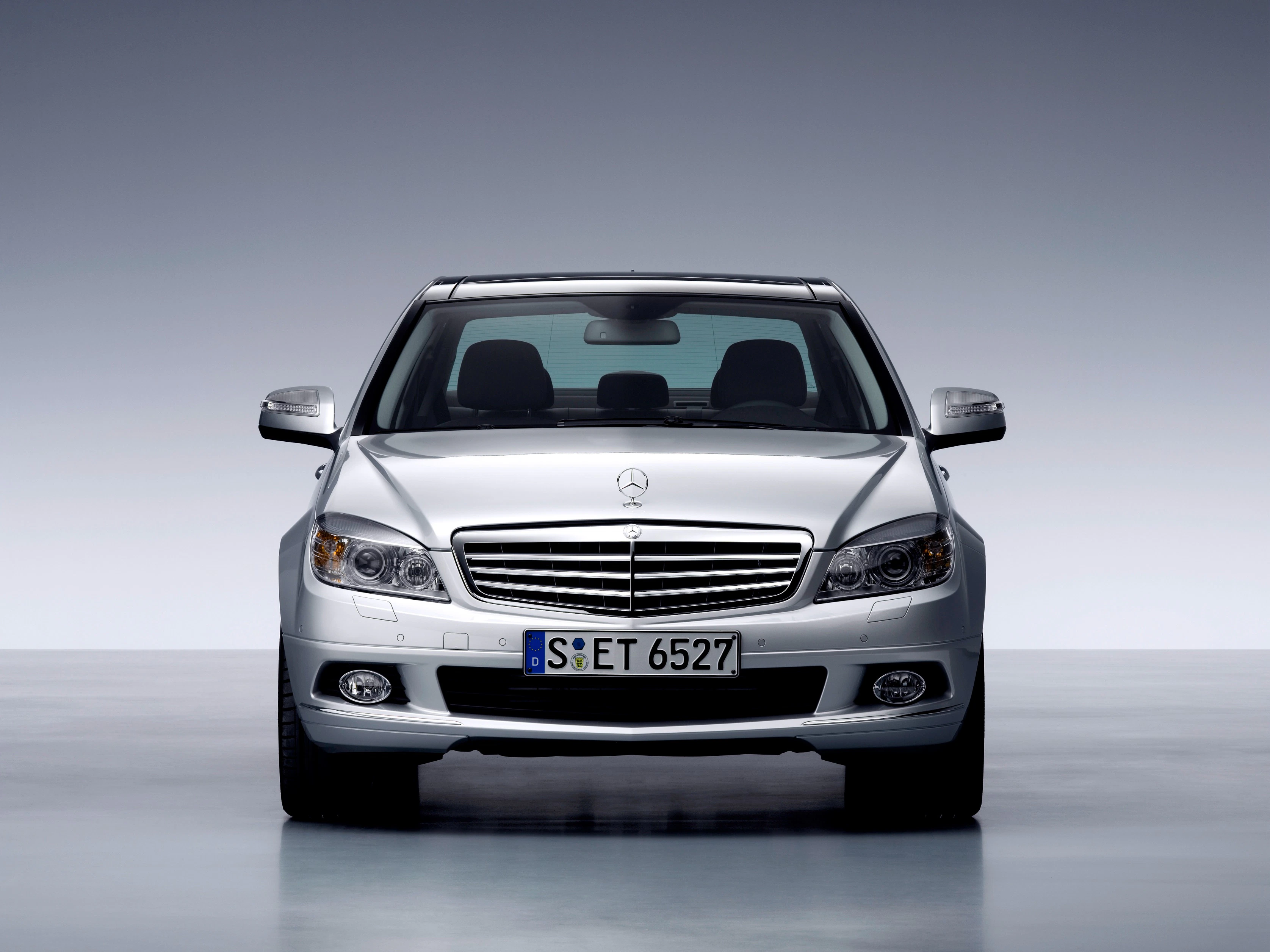 Silberner Mercedes-Benz Limousine von vorne, in einem Studio fotografiert, mit glänzendem Lack und markantem Kühlergrill.