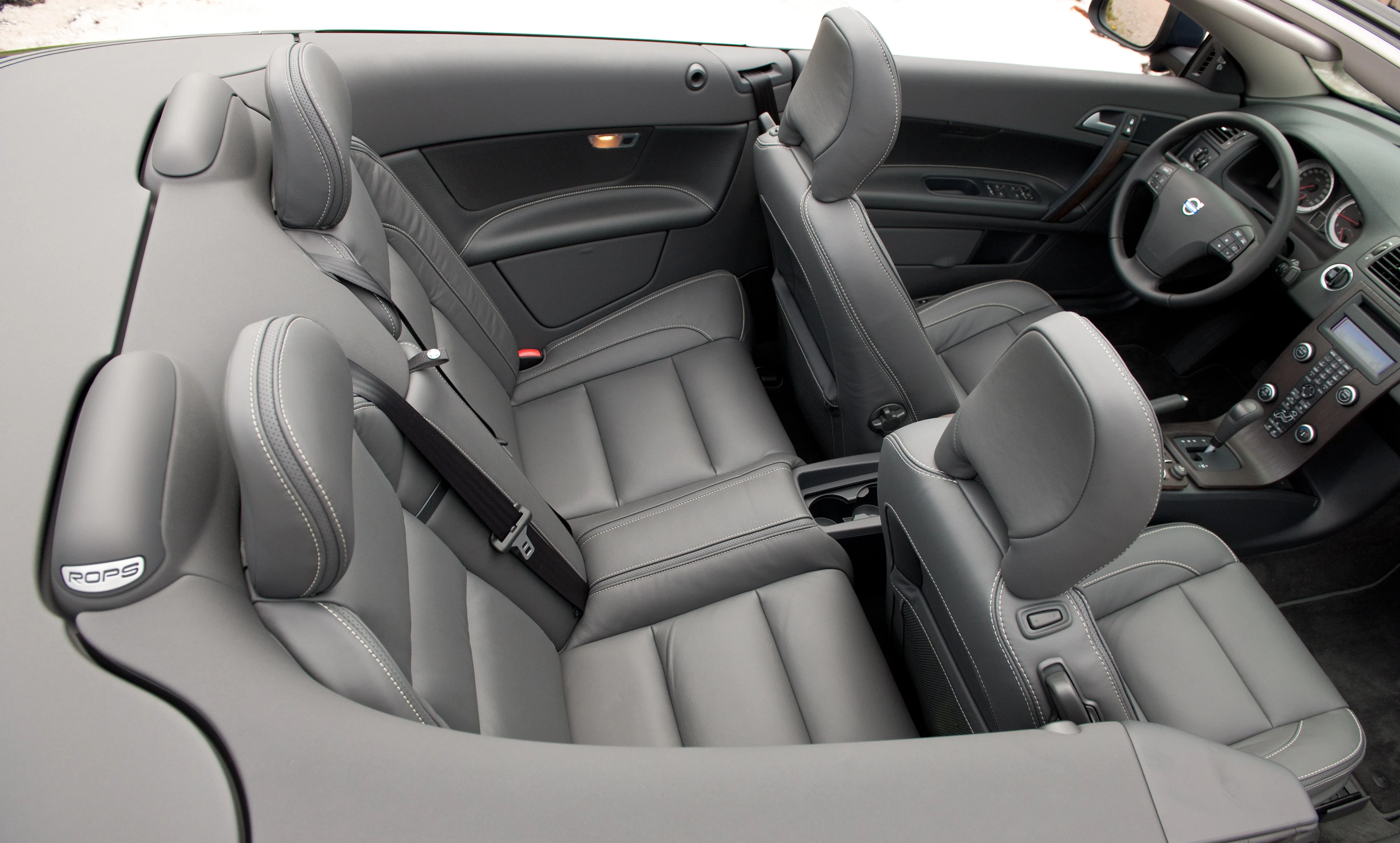 Innenraum eines Cabriolets mit vier grauen Ledersitzen und modernen Armaturen. Die Sitze sind offen, was einen luxuriösen Eindruck vermittelt.