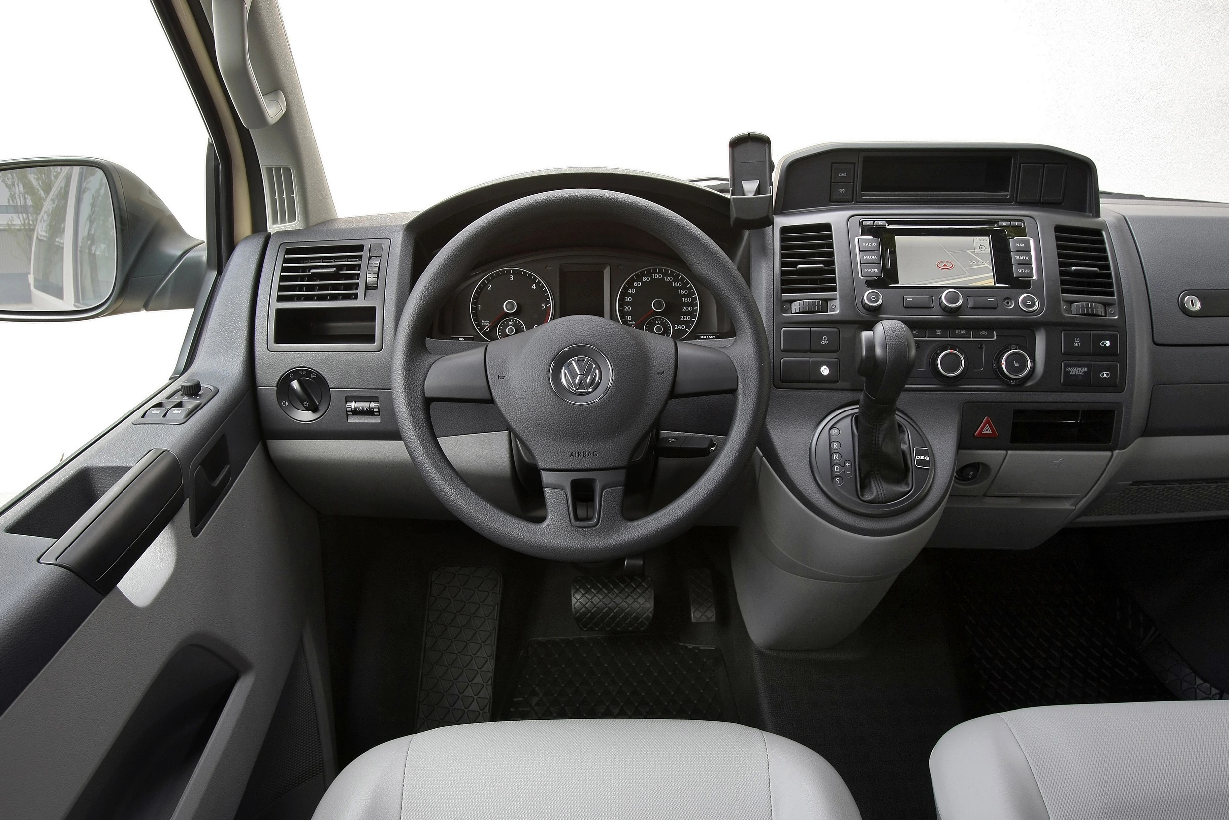 Innenansicht eines Fahrzeugcockpits mit Lenkrad, Schalthebel und Armaturenbrett inklusive Radio und Lüftungsschlitzen.