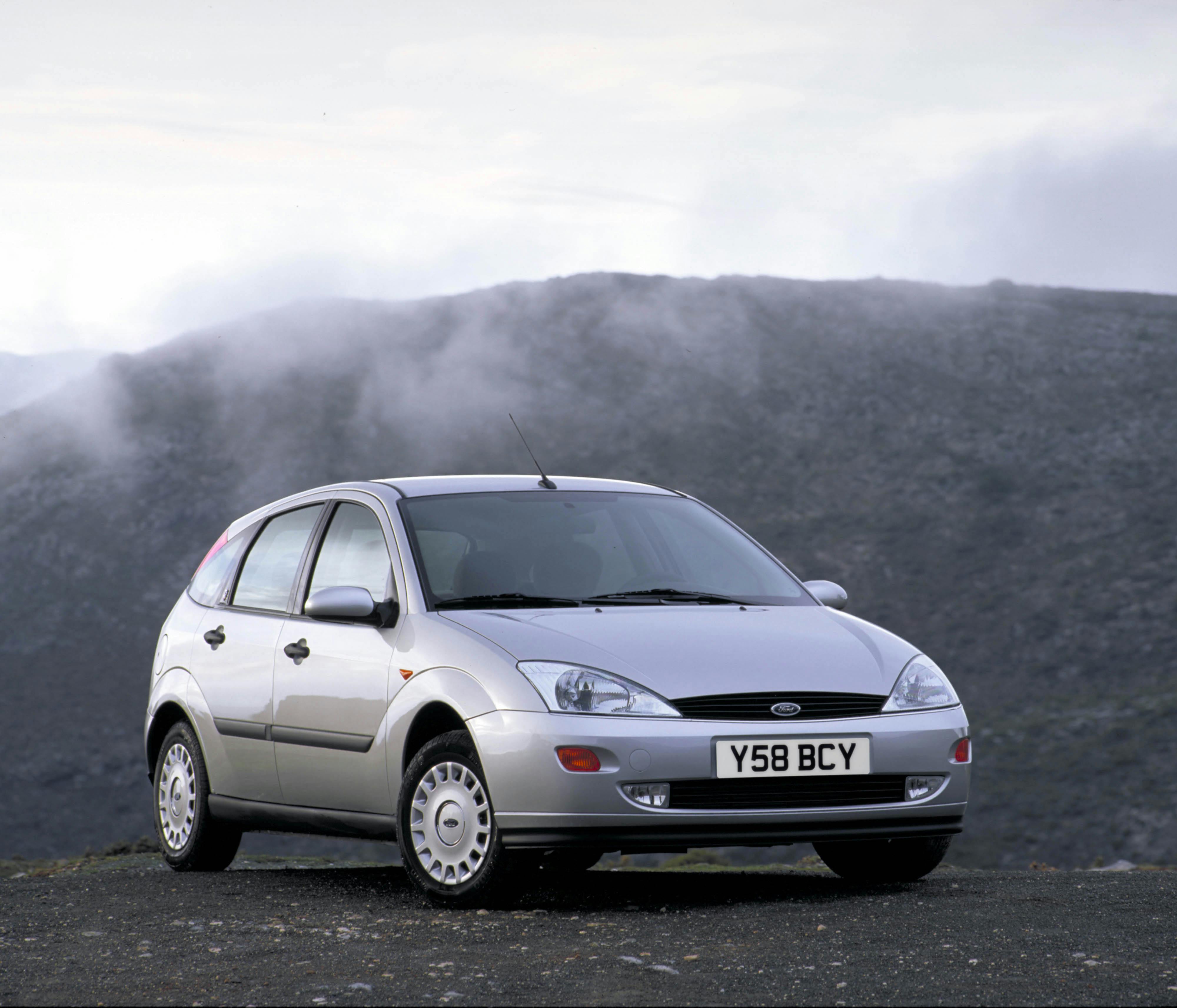Silberner Ford Focus der ersten Generation steht auf nebelverhangenem Berg, beleuchtet von weichem Licht. Kennzeichen: Y58 BCY.