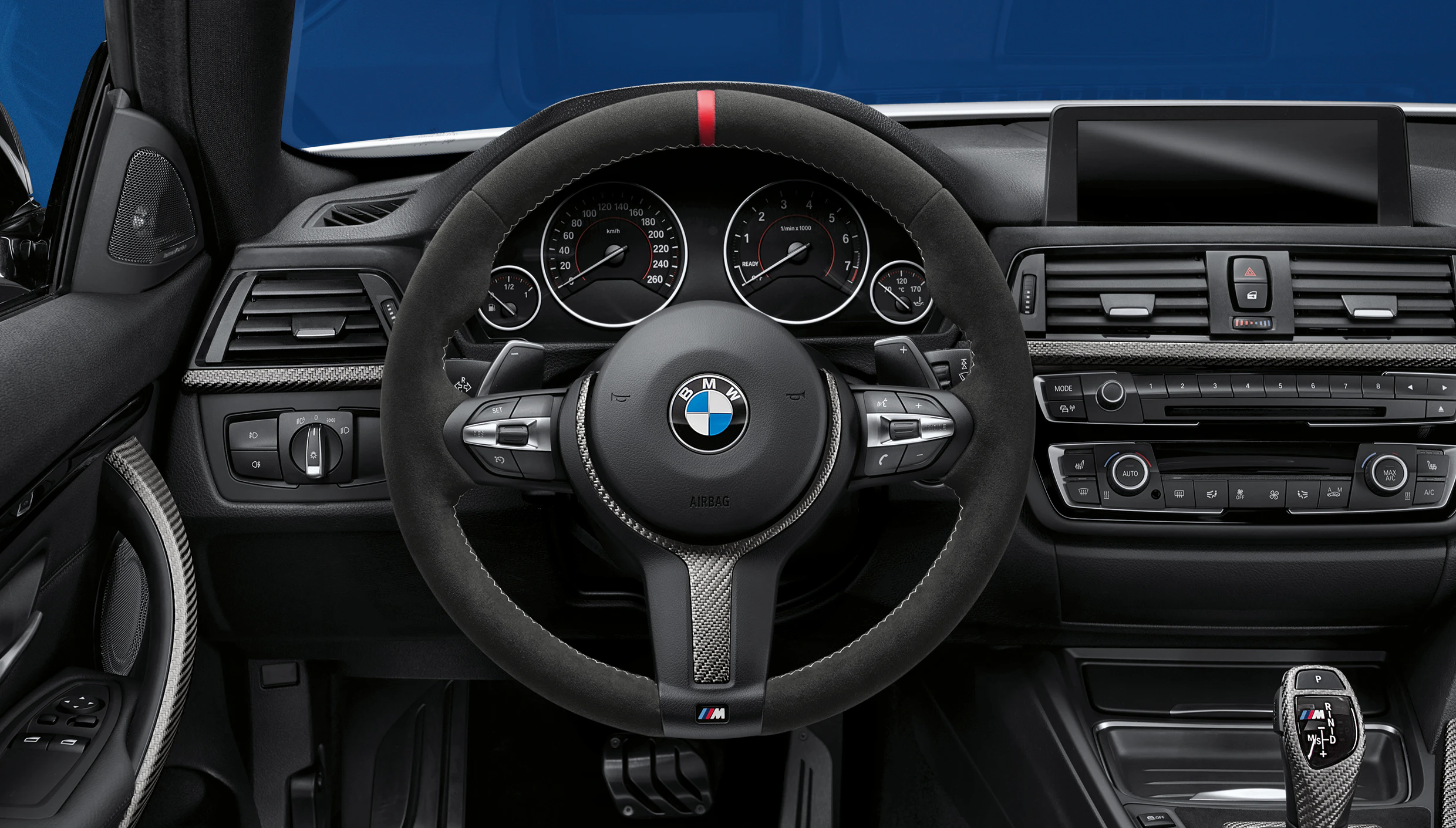 Innenraum eines BMW-Autos mit Lenkrad, Armaturenbrett, Anzeigen und Ganghebel in eleganter, moderner Gestaltung.