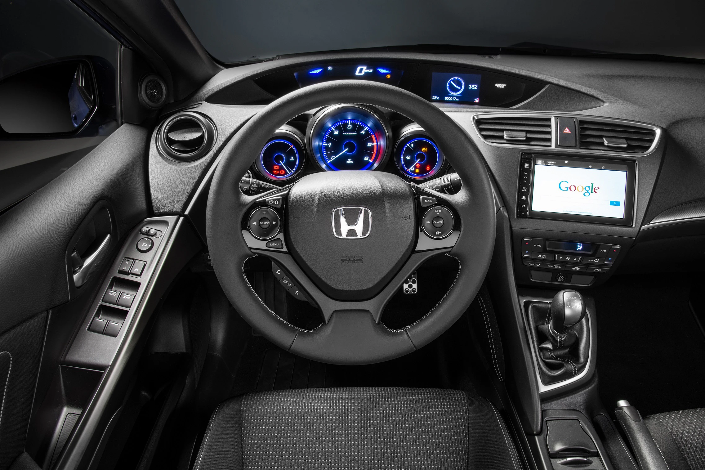 Lenkrad eines Honda-Autos mit modernen Instrumentenanzeigen und einem integrierten Bildschirm, der Google zeigt.