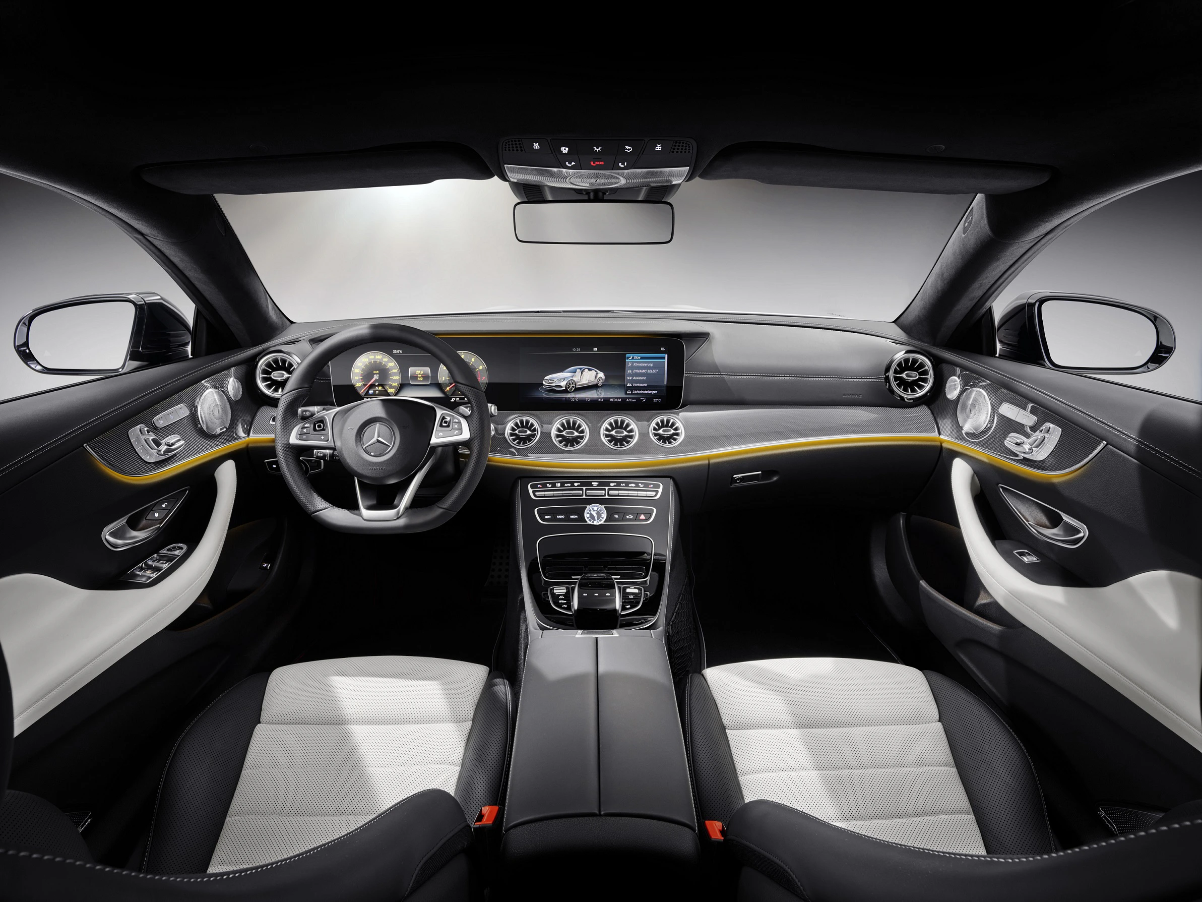 Innenraum eines modernen Autos mit Lederpolstern, sportlichem Lenkrad, digitalem Display und Mittelkonsole mit Steuerungsfunktionen.