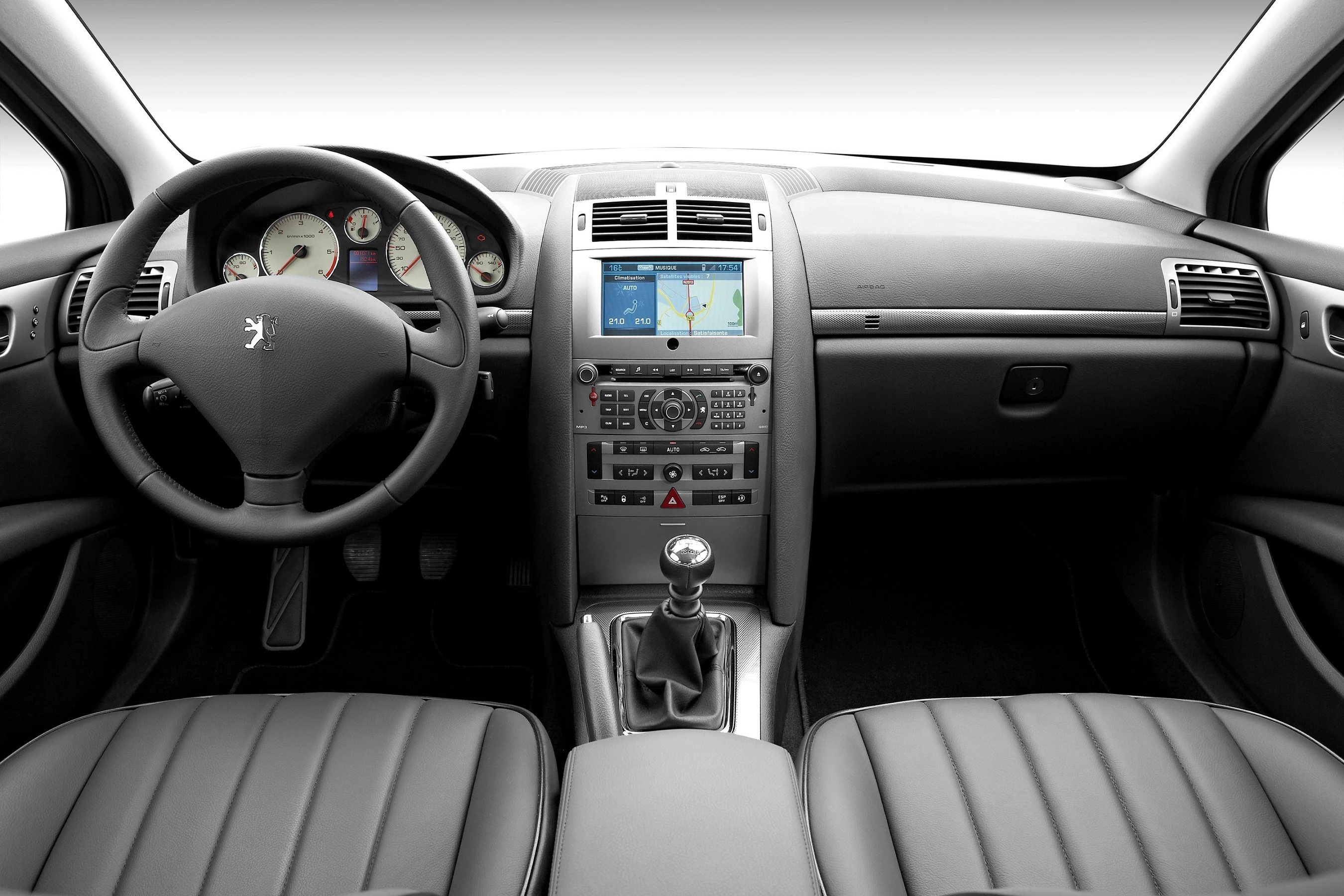 Innenraum eines Autos mit Armaturenbrett, Lenkrad, Schaltknüppel und Display mit Navigationssystem auf der Mittelkonsole.