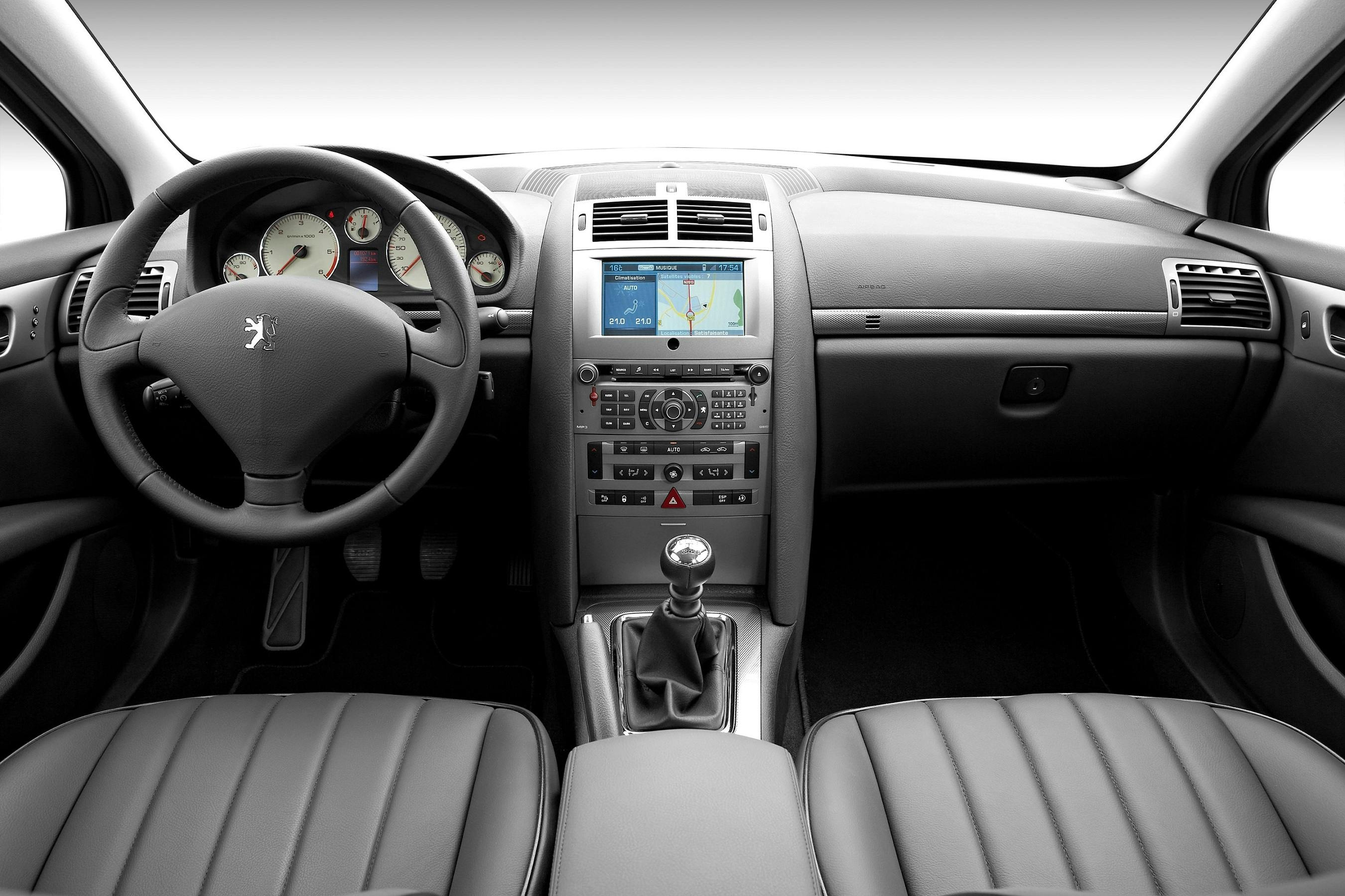 Innenraum eines Autos mit Armaturenbrett, Lenkrad, Schaltknüppel und Display mit Navigationssystem auf der Mittelkonsole.