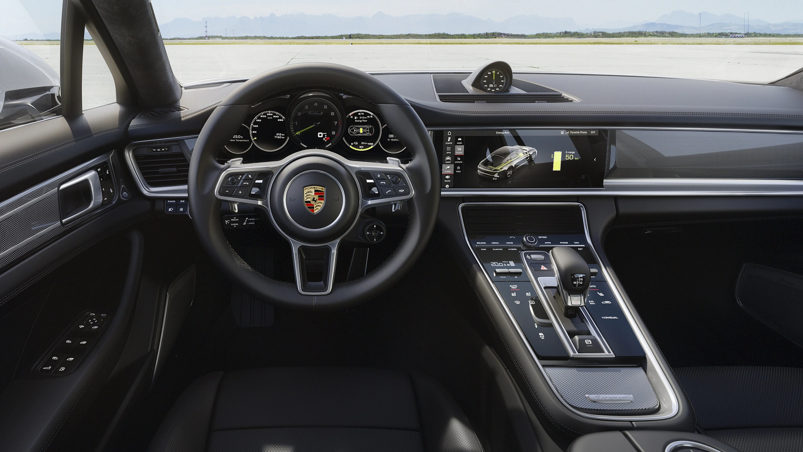 Innenraum eines Porsche-Autos mit modernen Instrumenten, Lenkrad mit Logo, Infotainment-Bildschirm, Mittelkonsole und eleganter Ausstattung.