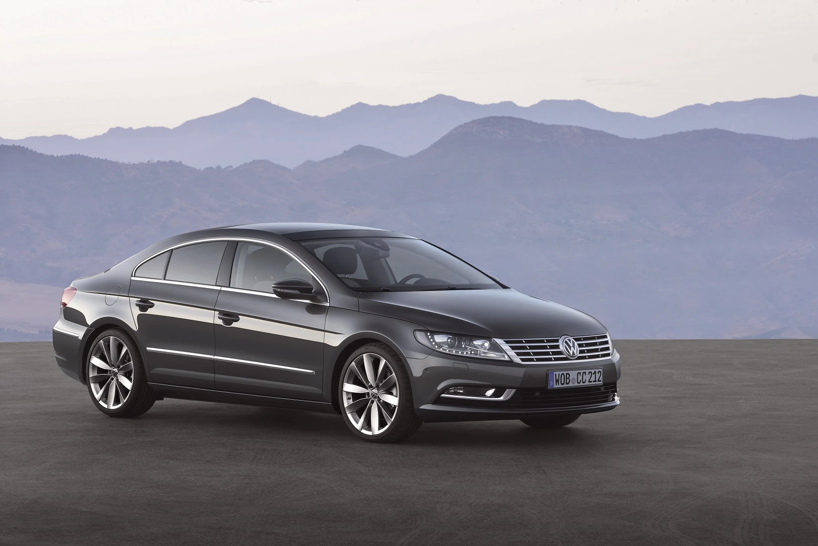 Schwarzer Volkswagen CC steht auf einer ebenen Fläche vor einer Berglandschaft bei Tageslicht.