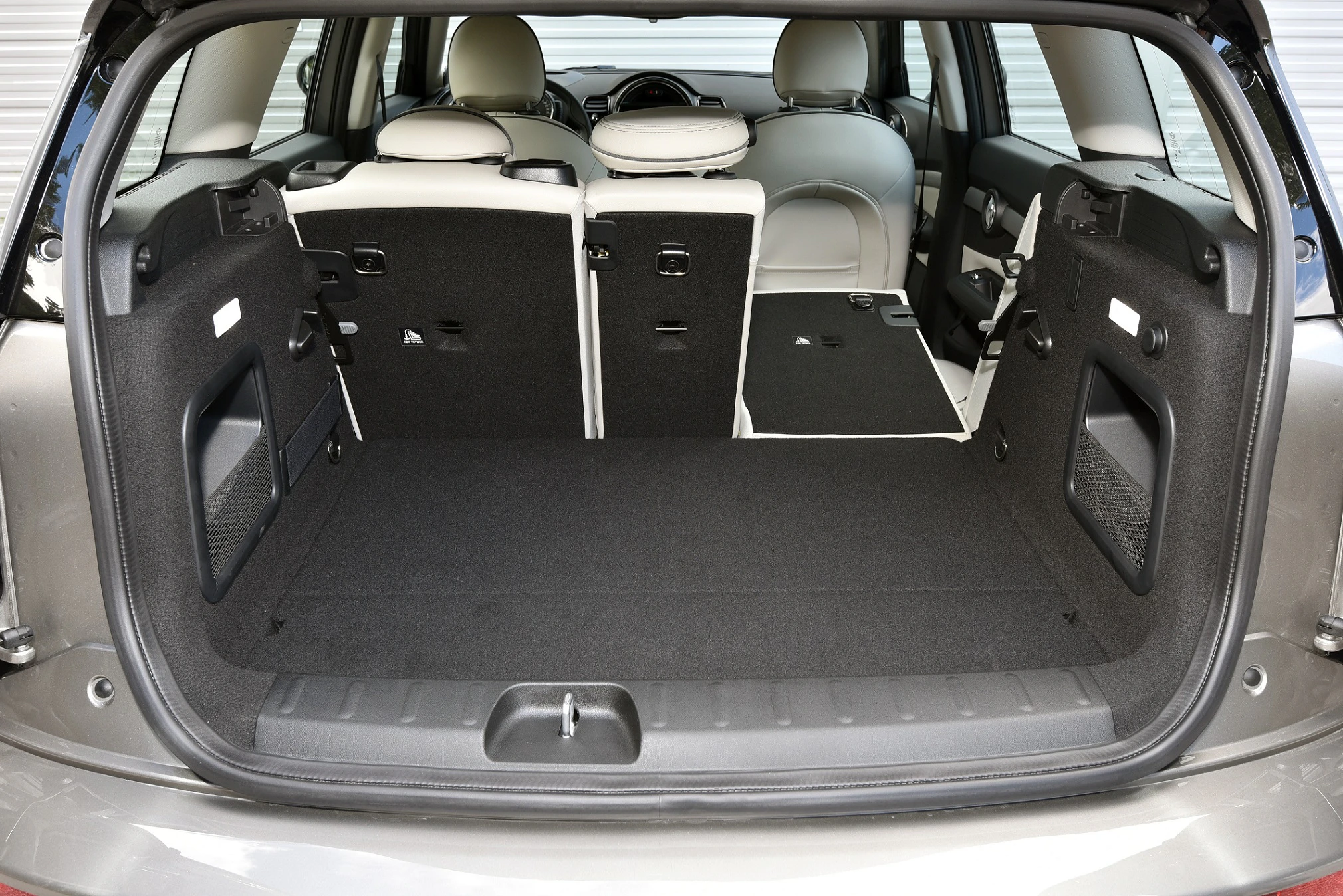 Kofferraum eines Autos mit umgeklappten Rücksitzen für mehr Ladefläche, grauer Innenraum, Überblick von hinten.