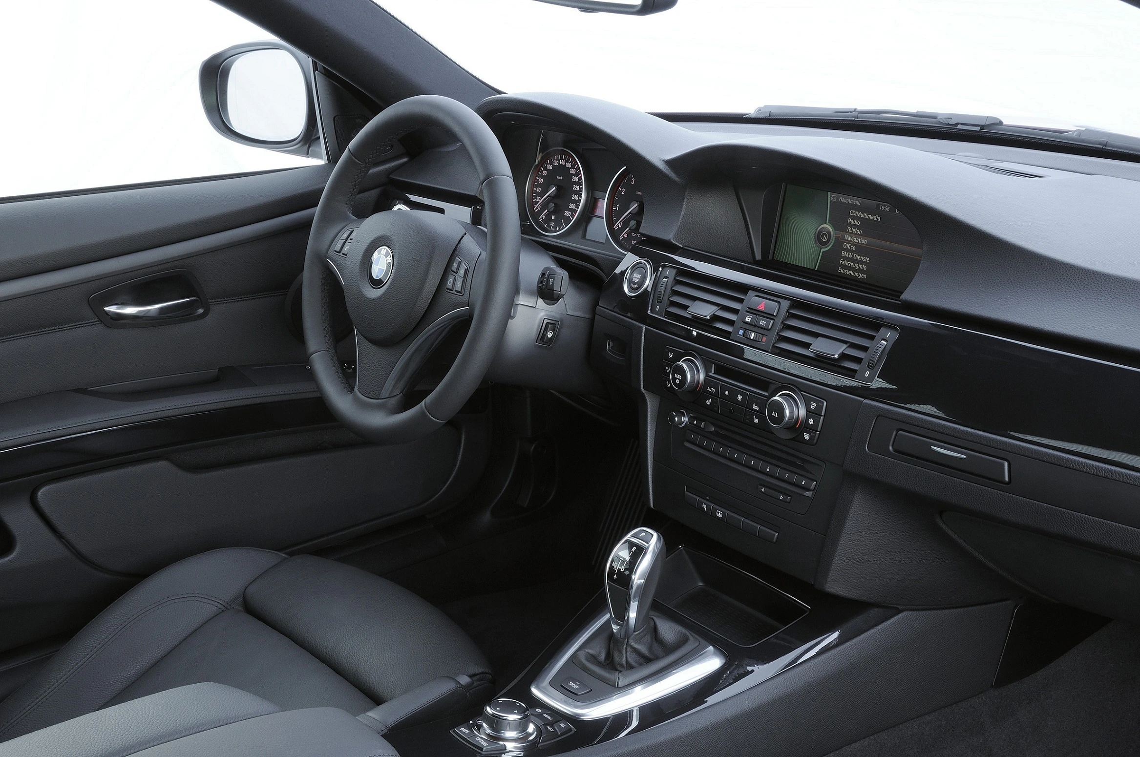 Innenraum eines modernen Autos mit Lederpolstern, Lenkrad, Tachometer und Infotainmentsystem. Schaltknauf in der Mittelkonsole.