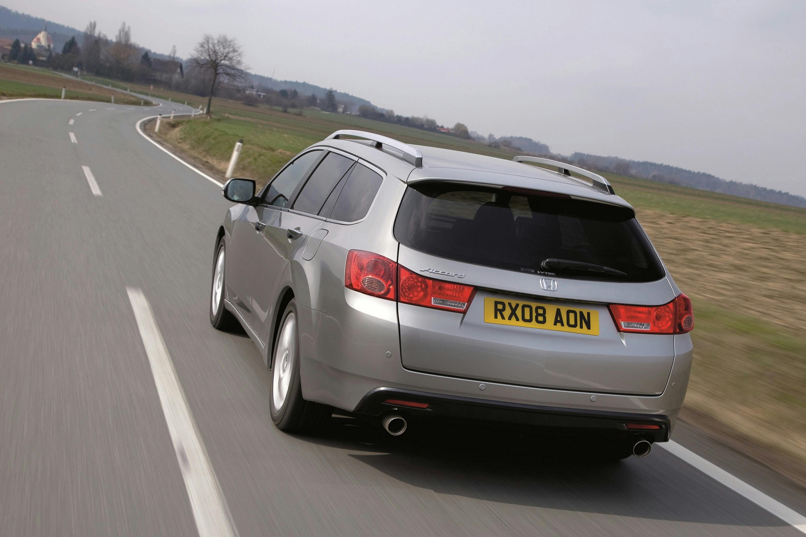 Silberner Kombi fährt auf einer Landstraße mit Wiesen im Hintergrund. Kfz-Kennzeichen „RX08 AON“.
