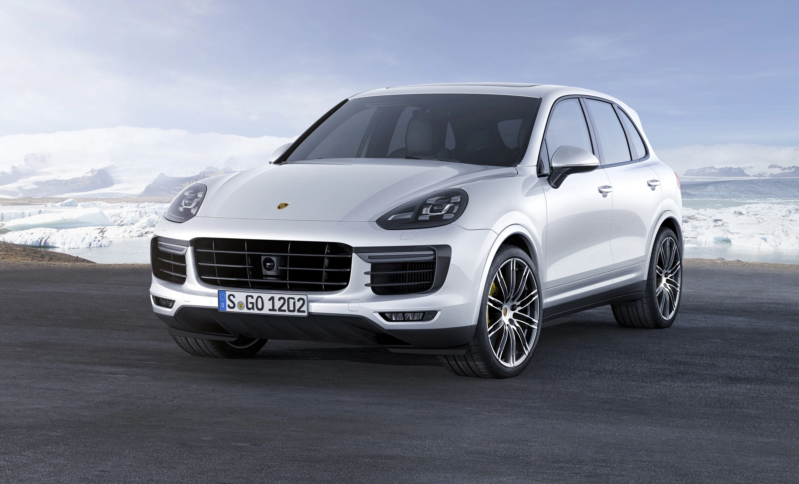Weißer SUV parkt vor verschneiter Landschaft. Sportliches Design mit glänzenden Felgen und markantem Kühlergrill.