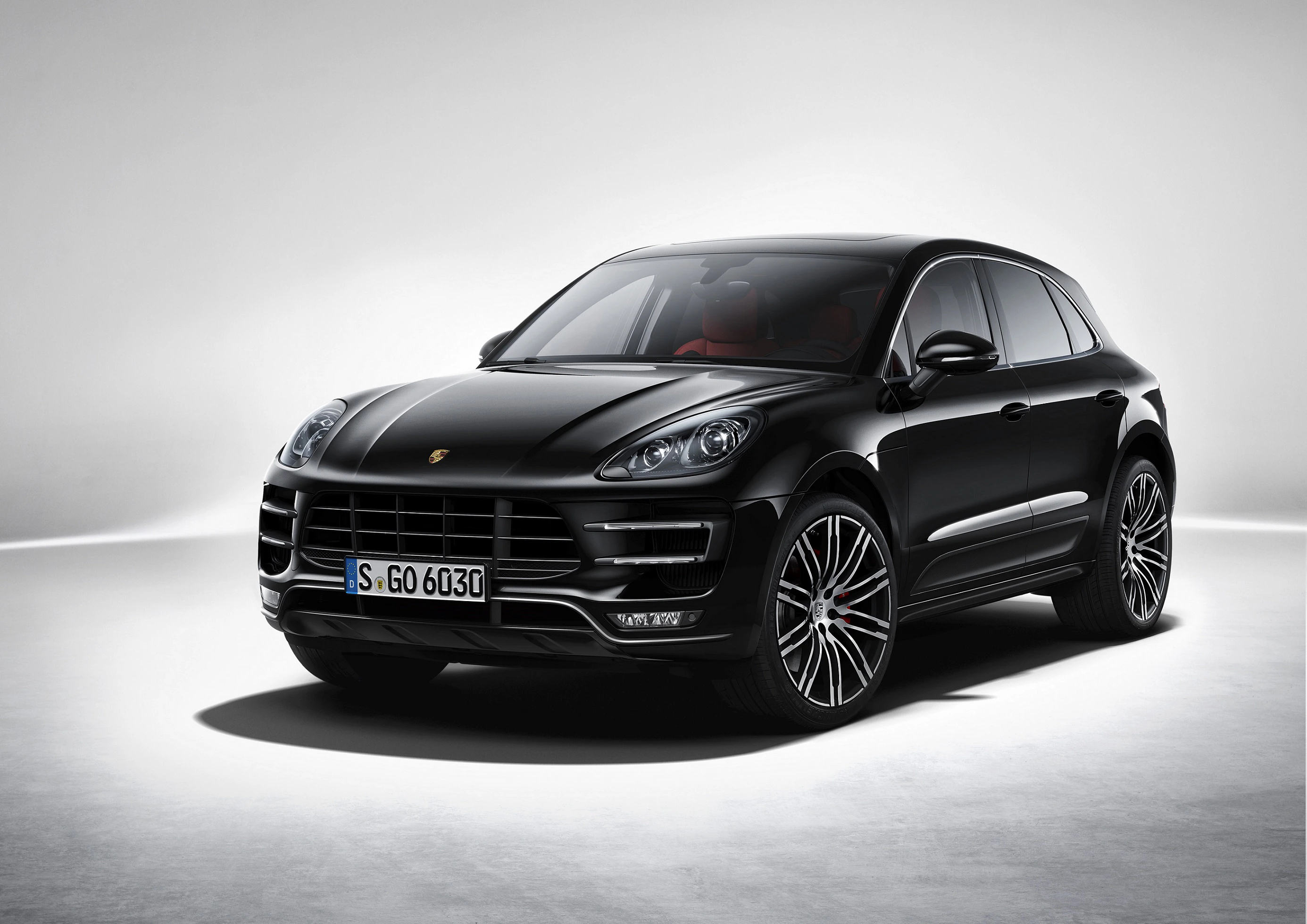Schwarzer SUV mit glänzendem Lack, stilvollem Design, markanten Felgen und beleuchtetem Markenlogo, steht in einem hellen Studio.
