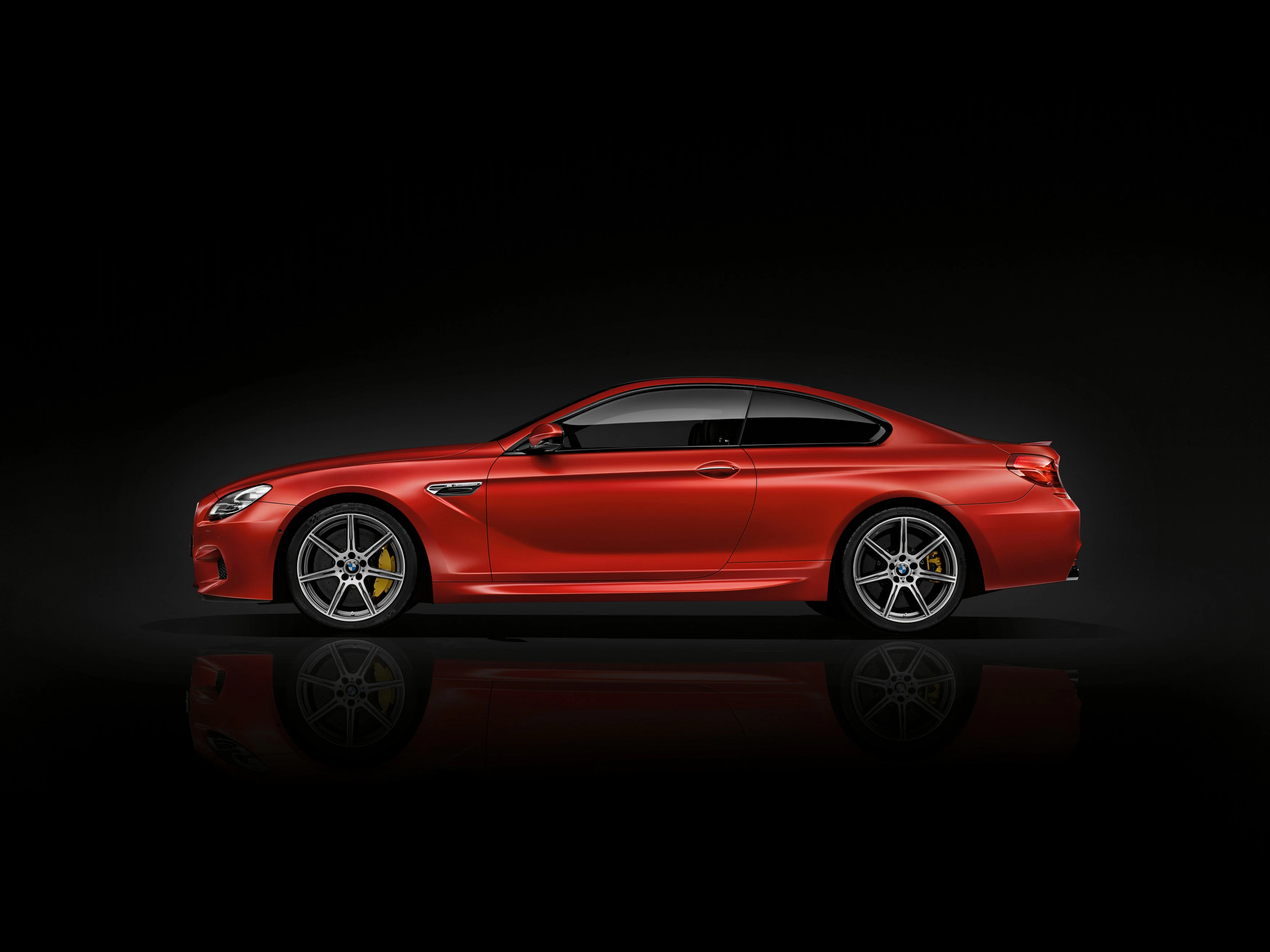 Rotes Sportcoupé vor schwarzem Hintergrund, seitliche Ansicht. Elegantes Design mit glänzenden Oberflächen und gelben Bremssätteln.