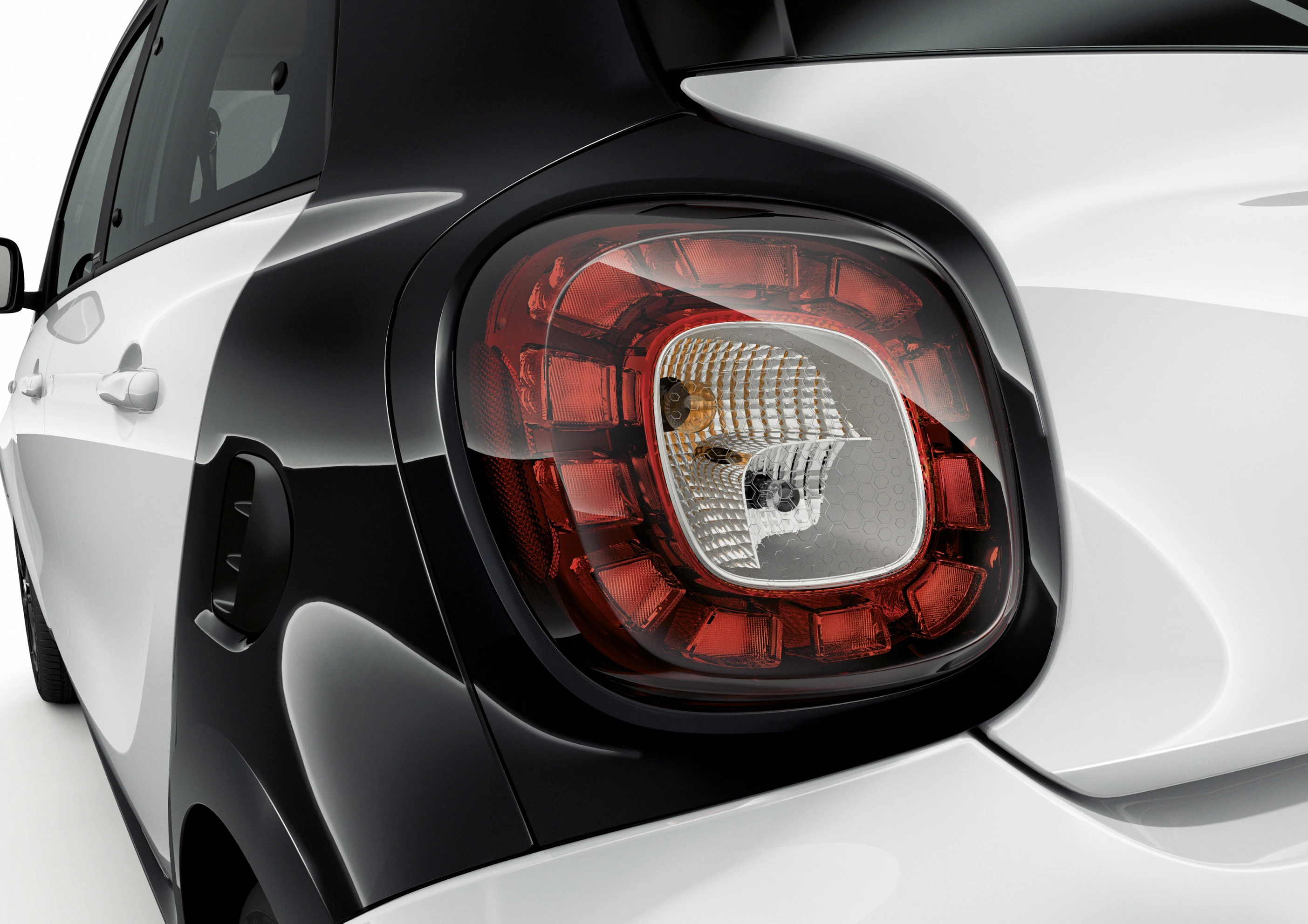 Nahaufnahme eines schwarz-weißen Autos, das den hinteren Teil mit der Rückleuchte zeigt. Moderne Designlinie und klare Oberfläche erkennbar.