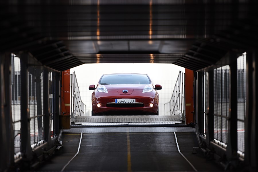 Rotes Auto auf einer Fährenrampe von hinten fotografiert. Auto ist mittig im Bild, umgeben von metallischen Strukturen der Fähre.