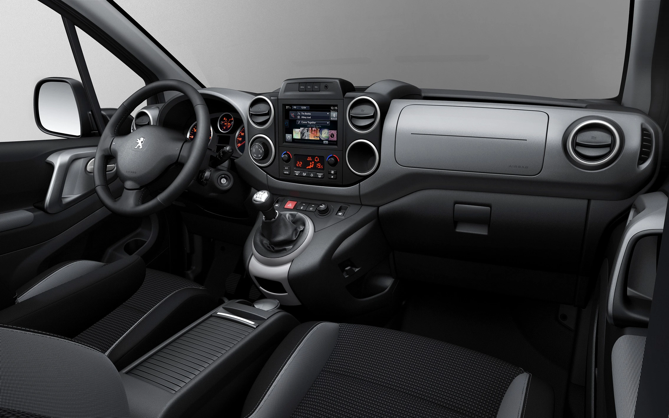 Innenraum eines modernen Autos mit Lenkrad, digitalem Armaturenbrett und Schaltknüppel. Das Interieur wirkt geräumig und funktionell.