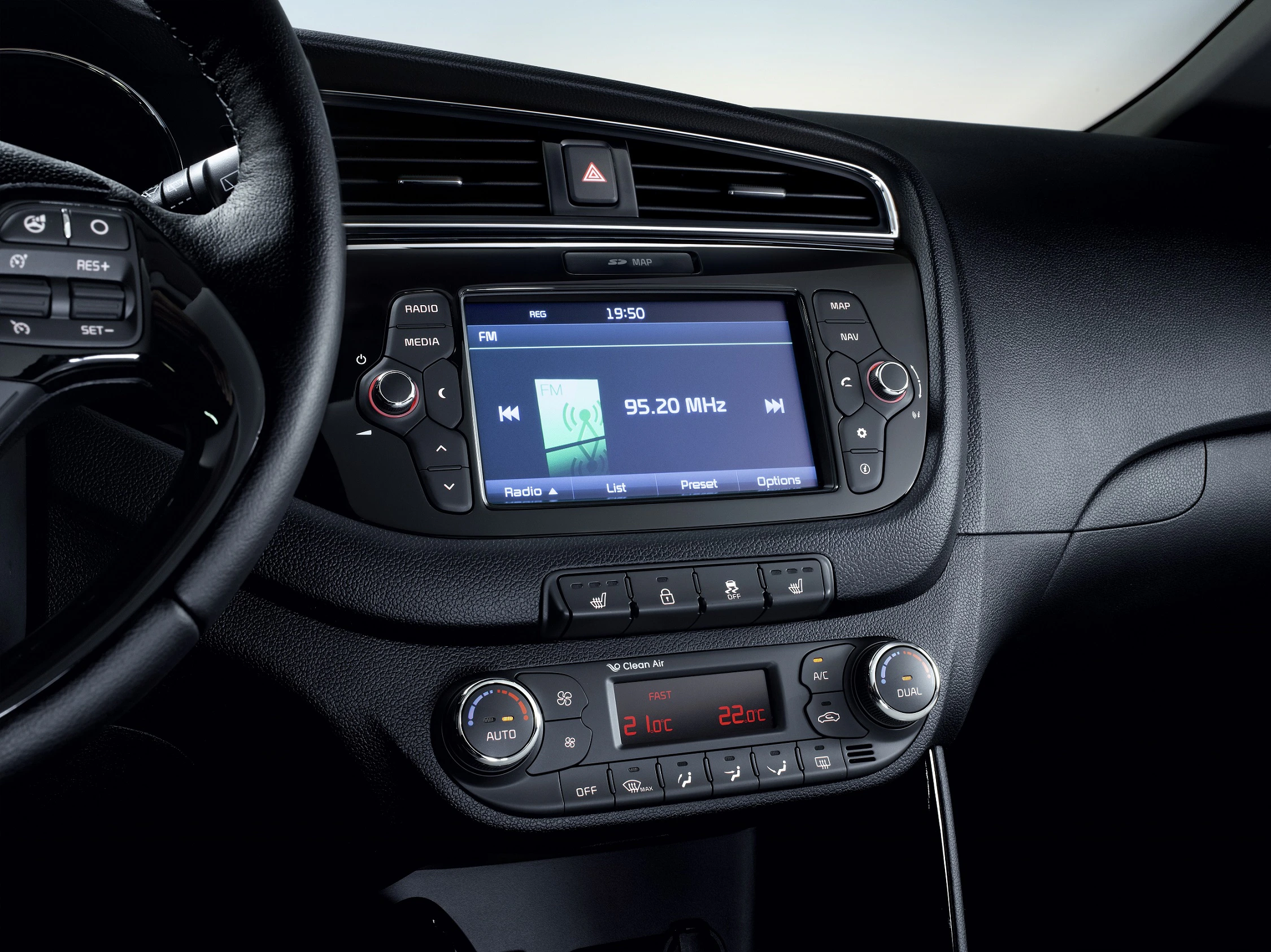 Auto-Innenraum mit Fokus auf Mittelkonsole: Radio-Display zeigt 95.20 MHz, Drehknöpfe für Klimaanlage darunter, Lenkrad links sichtbar.