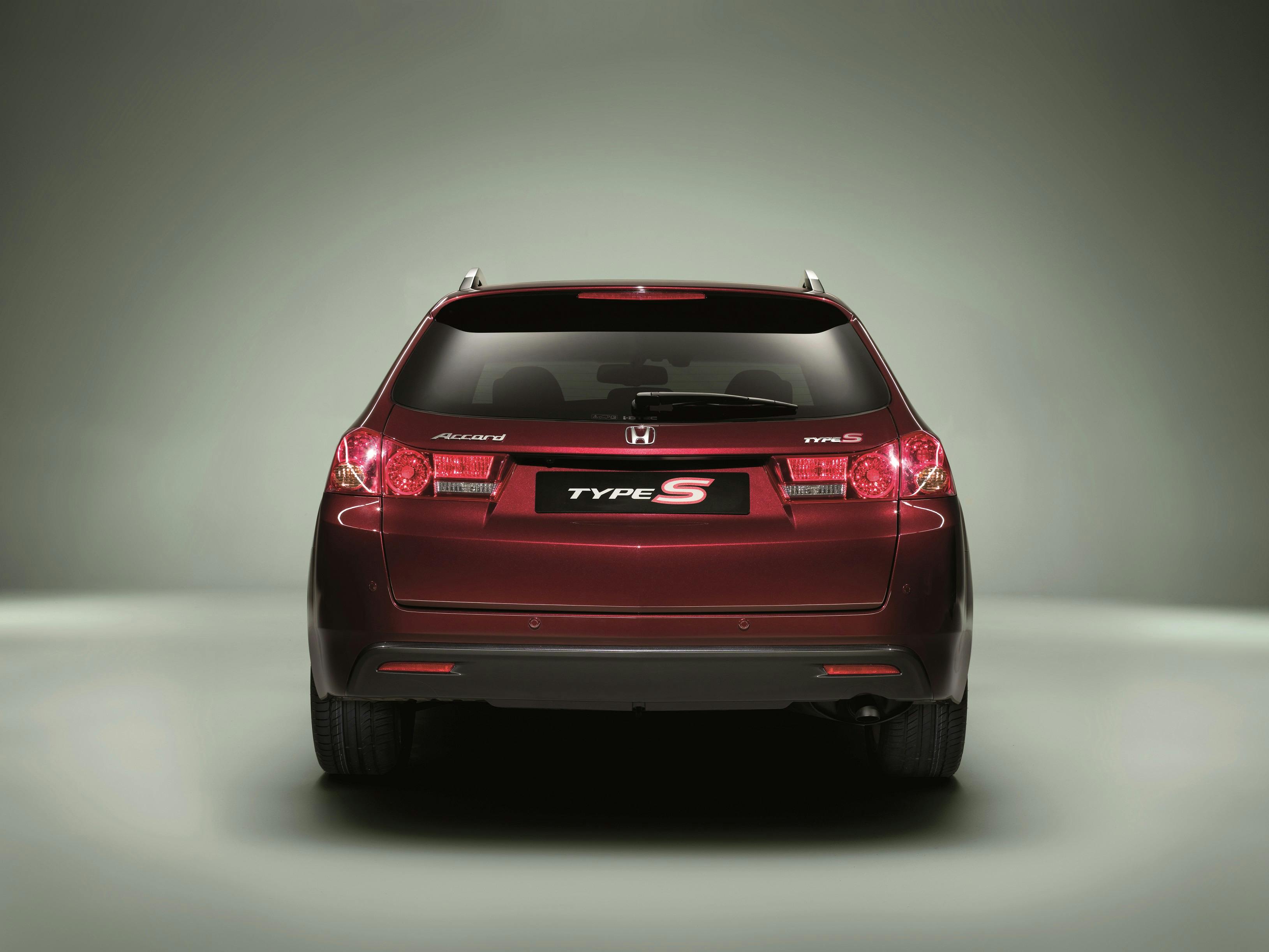 Heckansicht eines dunkelroten Honda Type S. Auto steht vor einem neutralen, graugrünen Hintergrund.