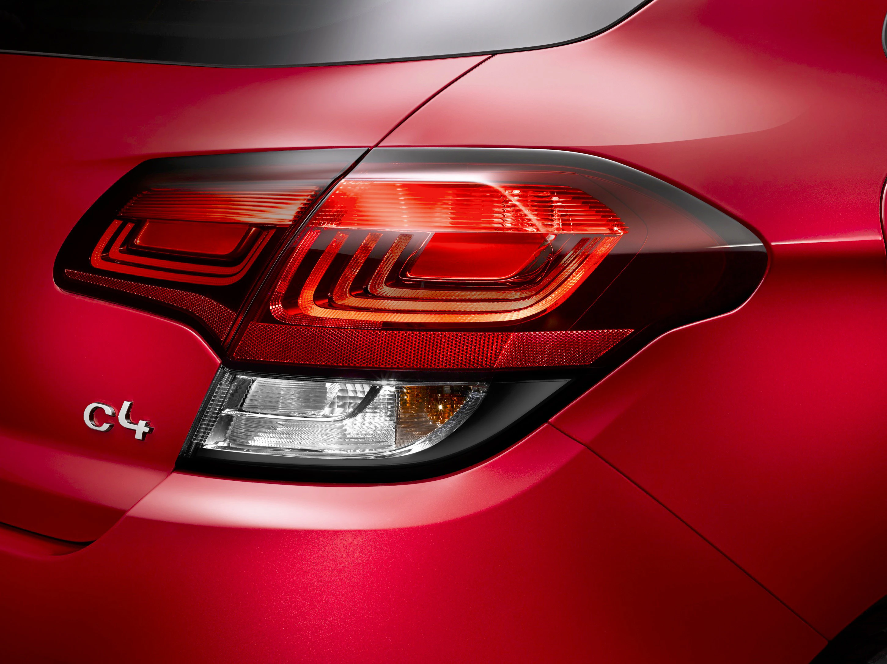 Rückansicht eines roten Autos mit elegantem Rücklichtdesign und C4-Emblem auf glänzender Karosserie.