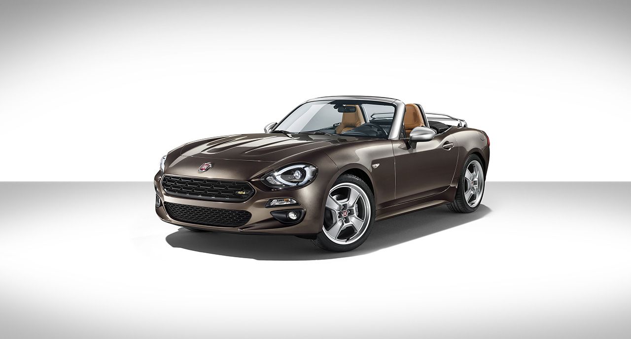 Brauner Fiat 124 Spider Cabrio vor weißem Hintergrund, Frontansicht lenkt Aufmerksamkeit auf stilvolles Design und glänzende Karosserie.