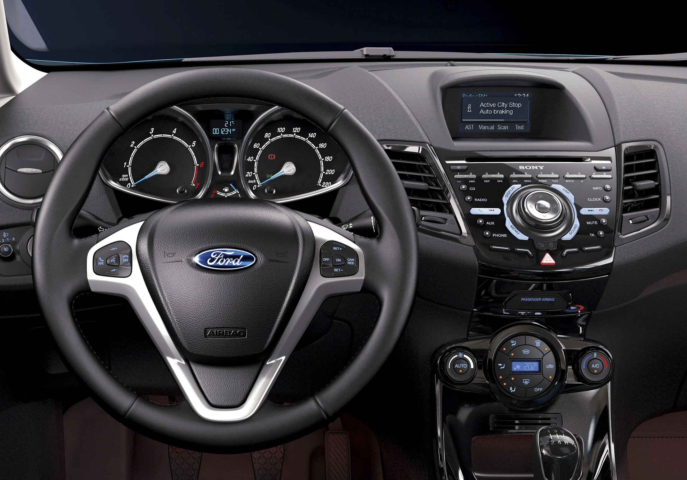 Nahaufnahme eines Ford-Autoinnenraums mit Lenkrad, Tachometer und zentralem Infotainmentsystem, das Radiosender anzeigt.