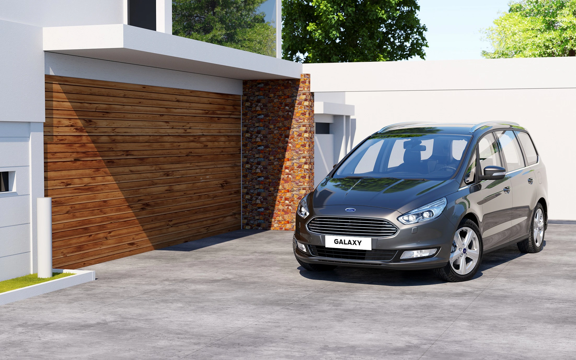 Graues Auto parkt auf einer Einfahrt vor einer modernen Garage mit Holztor und Ziegelwand. Im Hintergrund sind Bäume erkennbar.