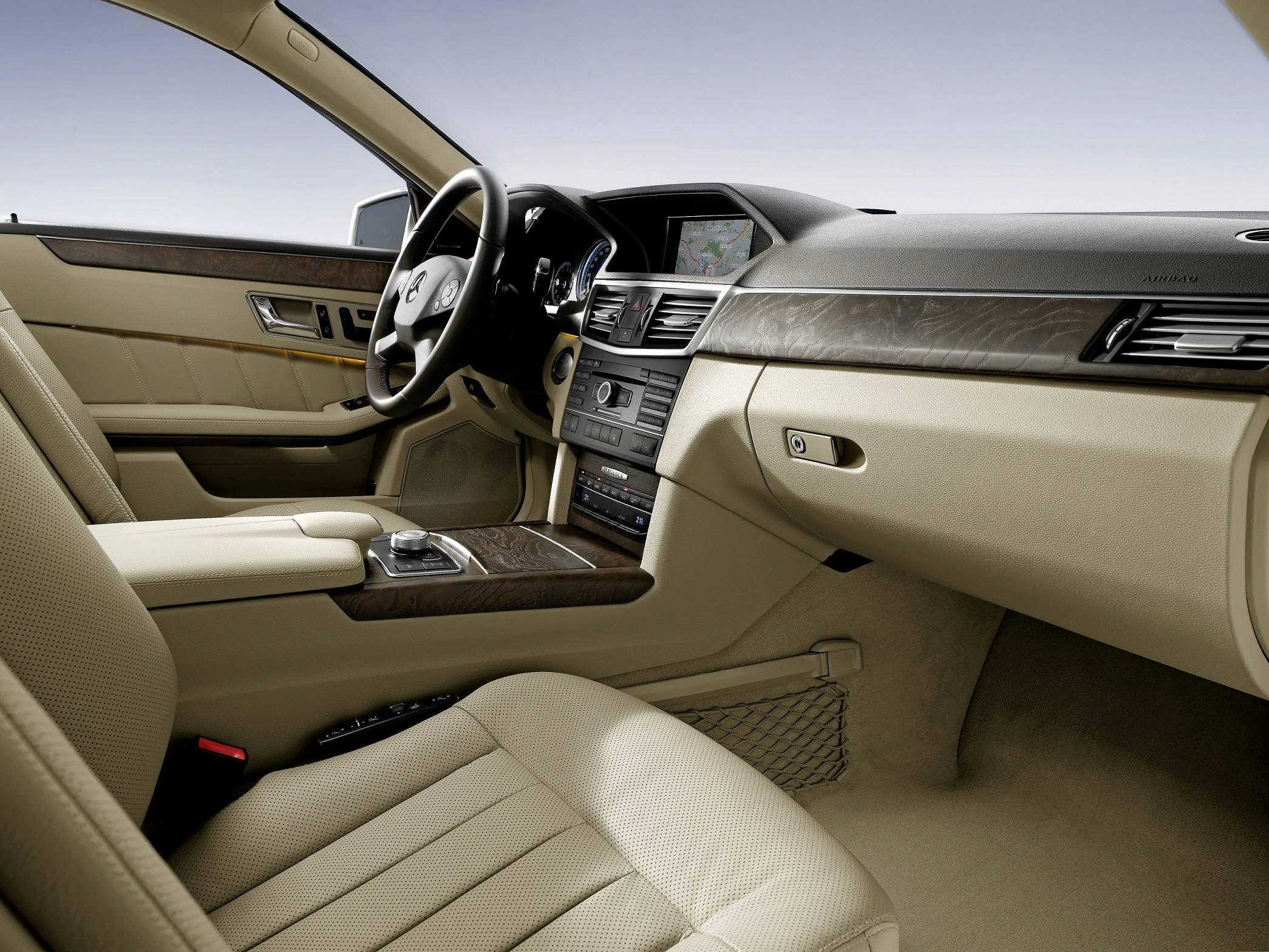 Luxuriöser Autoinnenraum mit beigen Ledersitzen, Holzverkleidungen und modernem Armaturenbrettdesign.