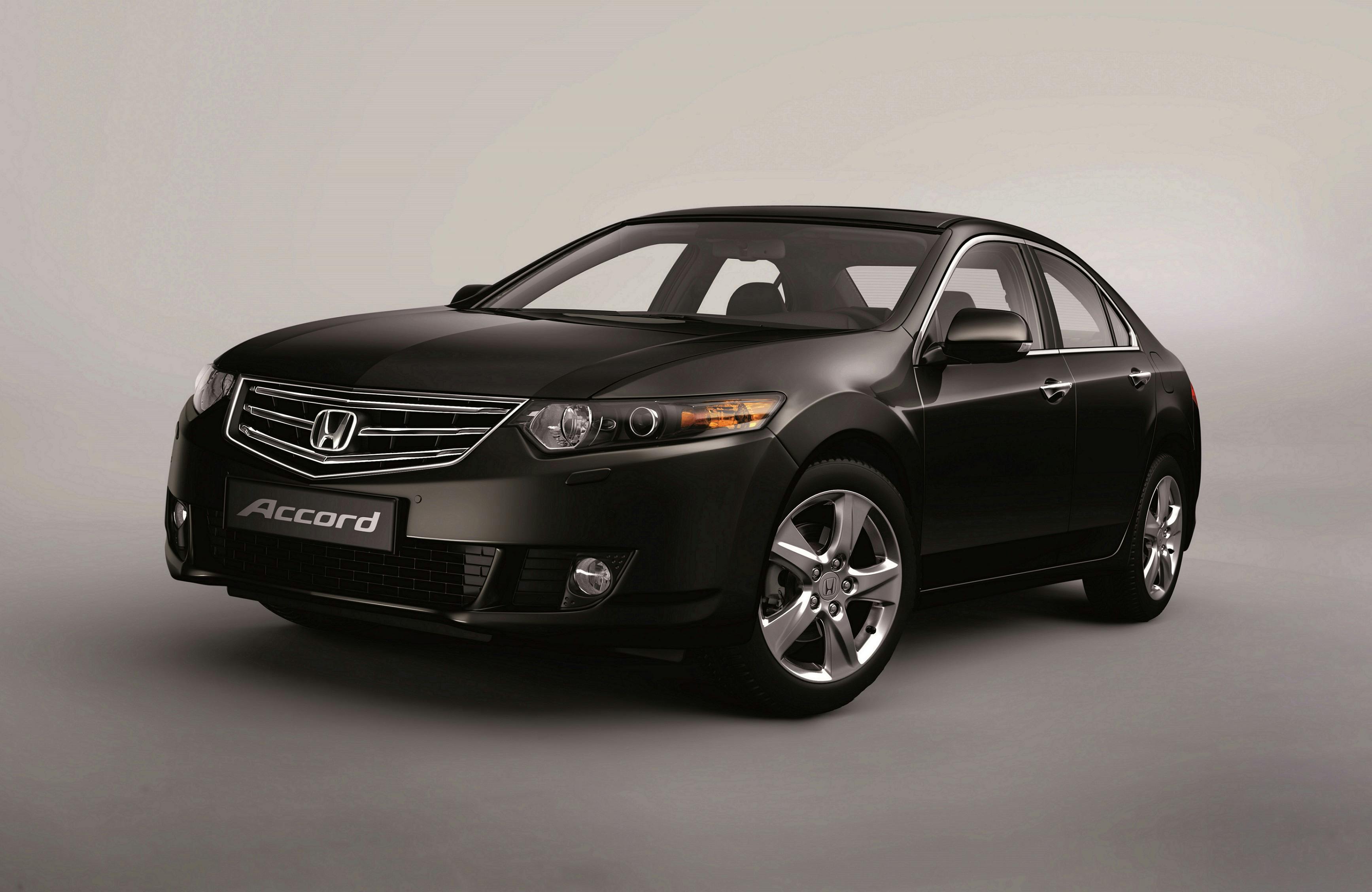 Schwarzer Honda Accord Limousine, seitlich von vorne fotografiert, auf grauem Hintergrund.