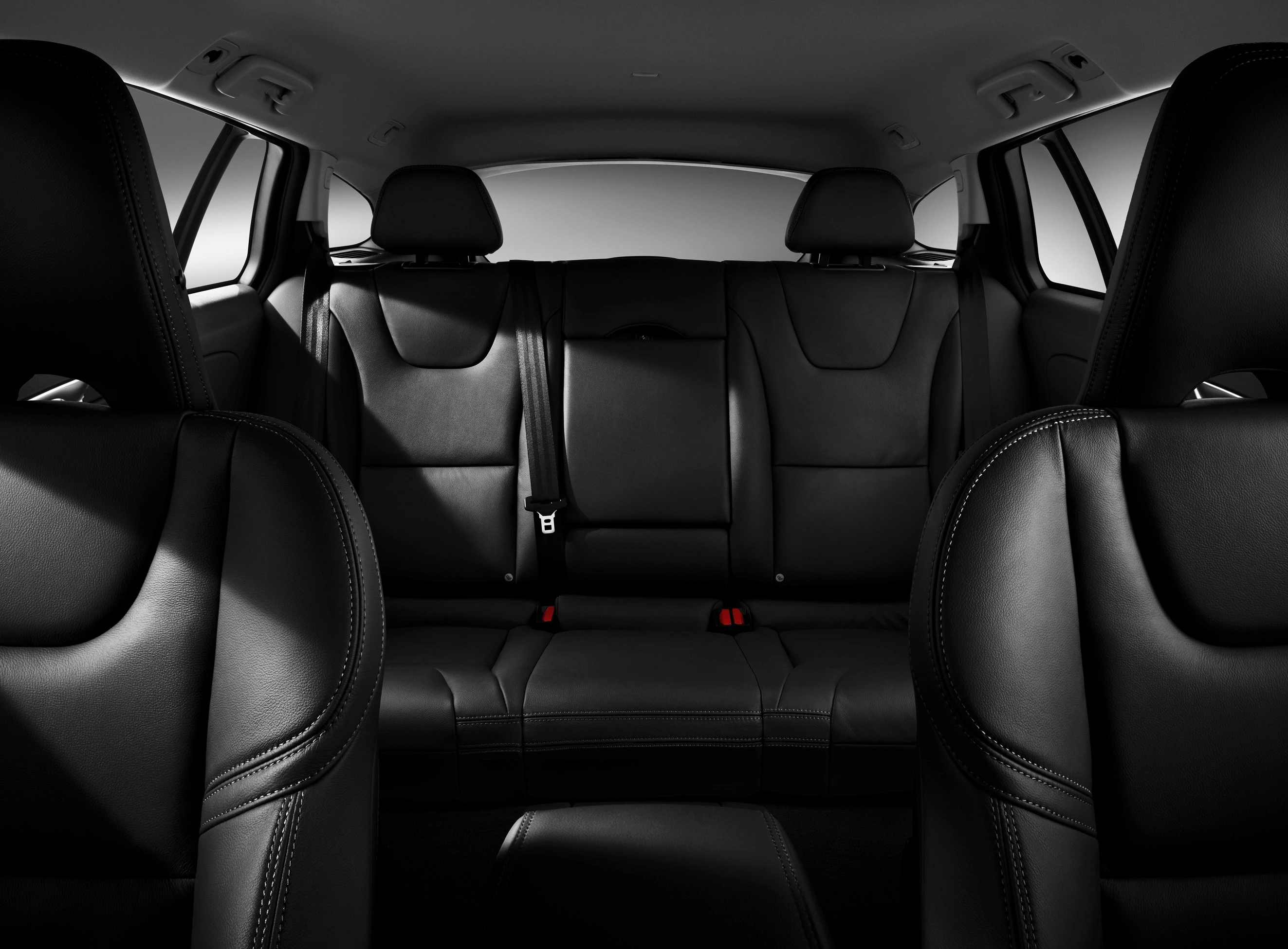 Innenraum eines Autos mit schwarzen Ledersitzen, Blick auf die Rückbank. Dunkles, elegantes Design, geräumige Sitzanordnung.