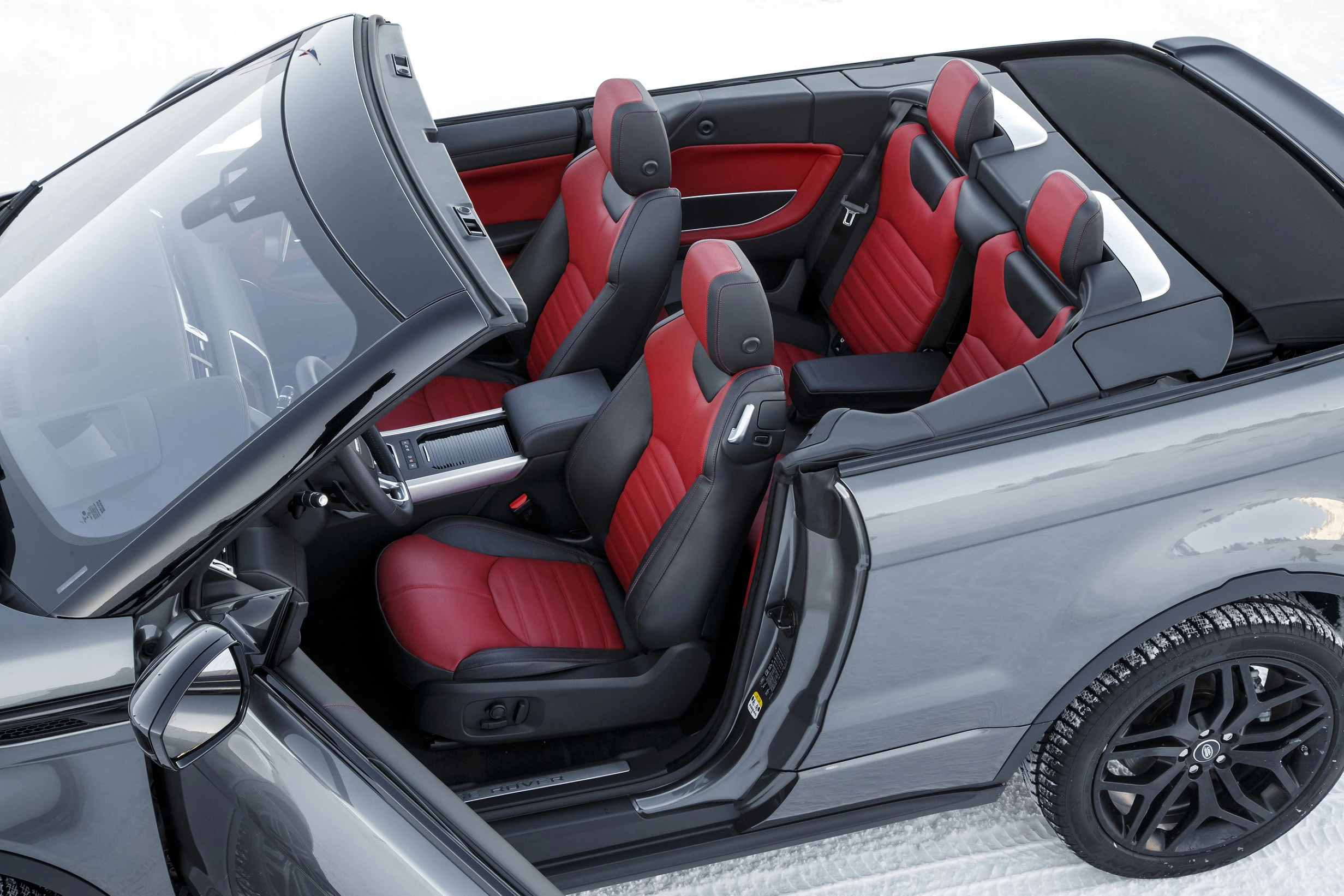 Cabriolet mit schwarzer und roter Lederausstattung, geparktem Position auf verschneitem Untergrund. Fünf Sitzplätze sind sichtbar.