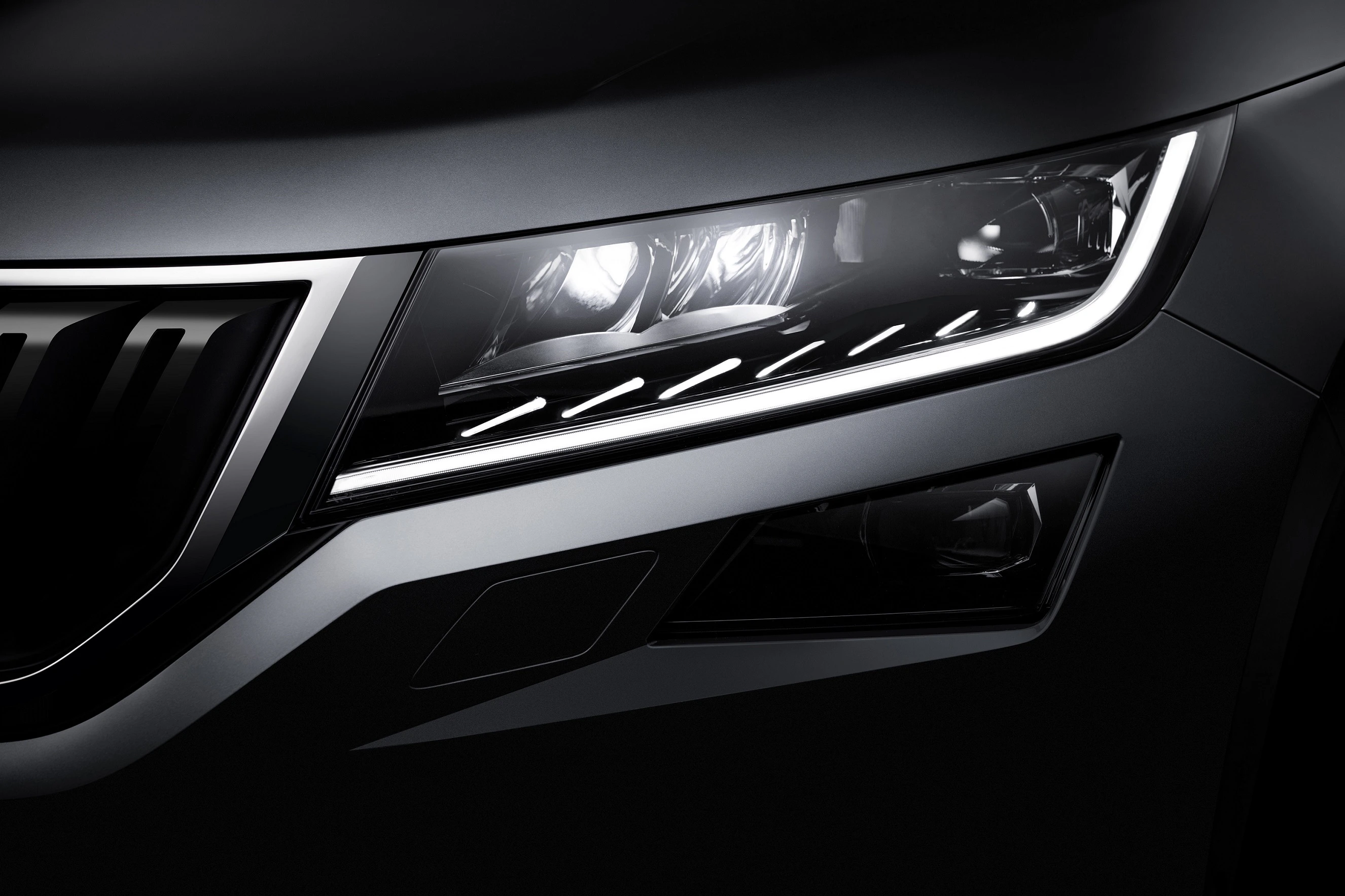 Nahaufnahme eines modernen Autoscheinwerfers mit LED-Leuchten und stilvoller Kurvenführung, die ein elegantes Design betont.